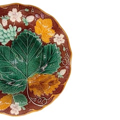 Assiette Wedgwood en majolique « Vigne et fraise » sur fond marron, anglaise, vers 1896
