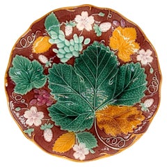 Assiette Wedgwood en majolique « Vigne et fraise » sur fond marron, anglaise, vers 1896