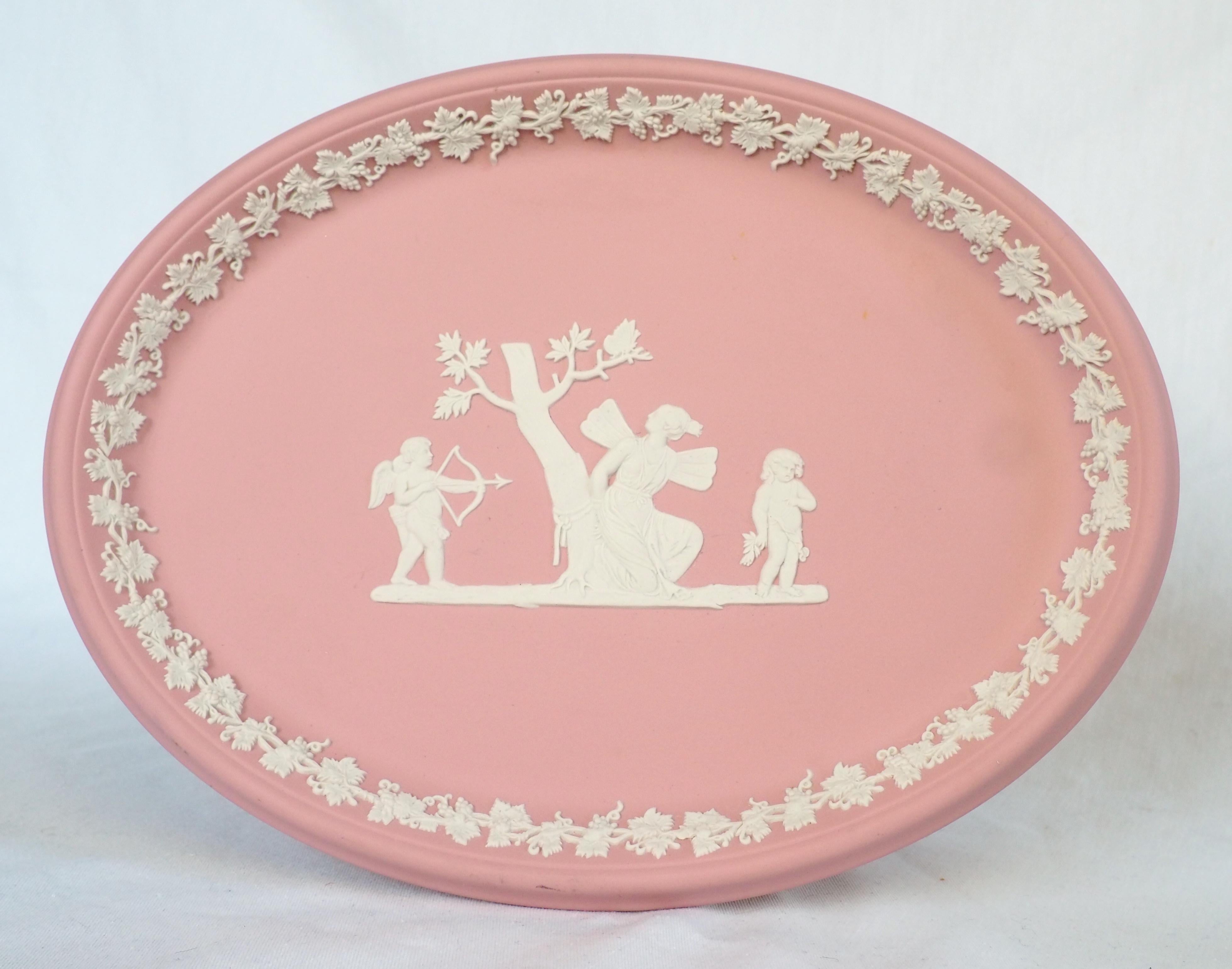 Large Wedgwood jasperware tray, beautiful neoclassical style item decorated with white antique-style scenes picturing Psyche with Cupid around drawing his bow ; rare version on a light pink background.
Second half of 20th century refined and highly