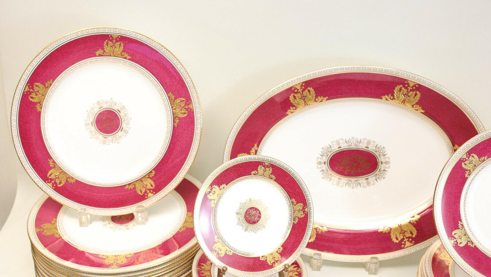 Wedgwood porcelain dinner service in Columbia raised gold and powder red for 12. A rare complete dinner service with the highly sought after raised gold variant in the Colombian pattern. A powdered red ground around the rims and to the center with