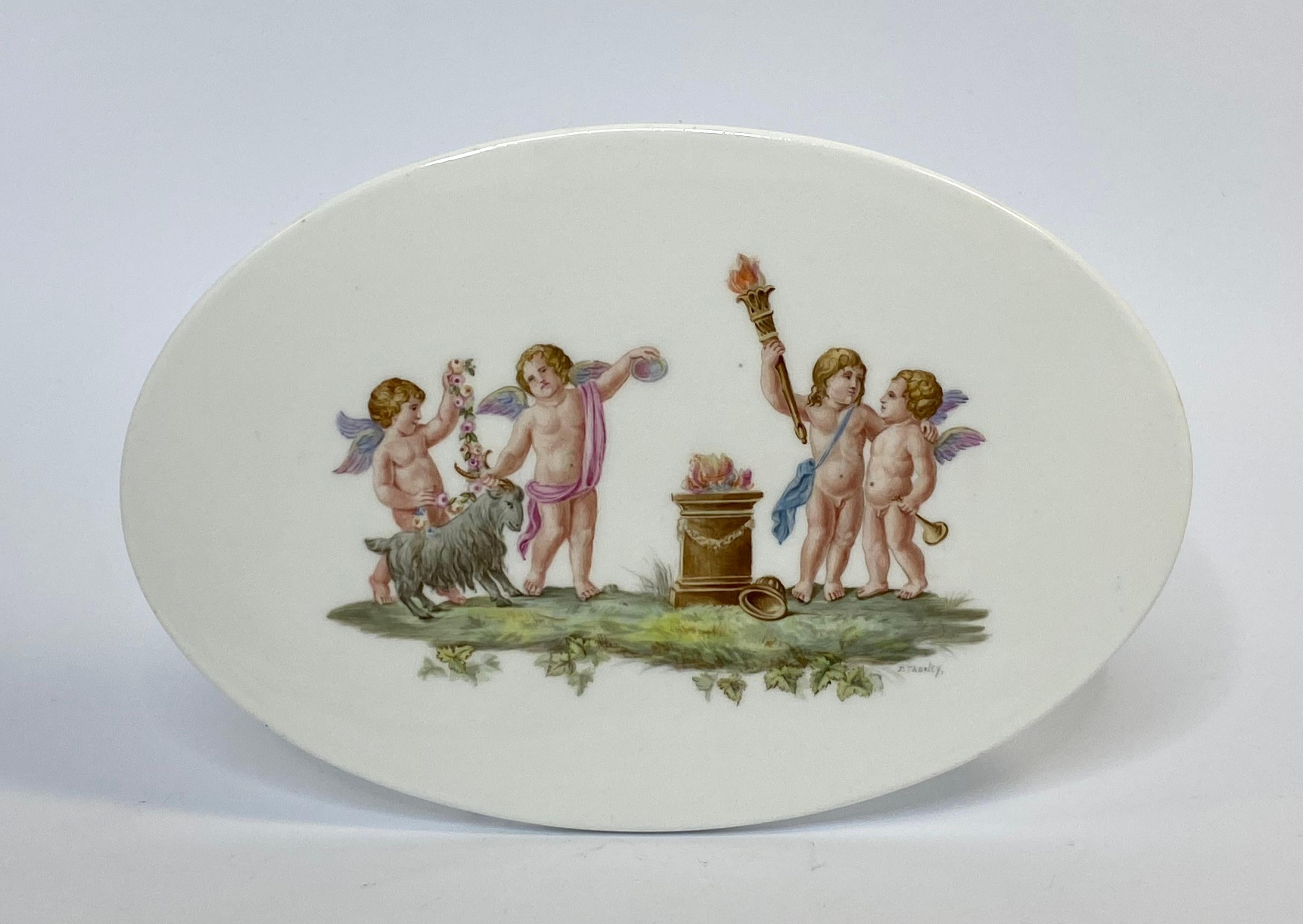 Wedgwood porcelain plaque, by Joseph Palin Thorley, c. 1910. The oval plaque, hand painted with a scene of four Putti, in Classical style, variously carrying a garland of flowers, a flaming torch, a trumpet, and one accompanied by a goat, before a