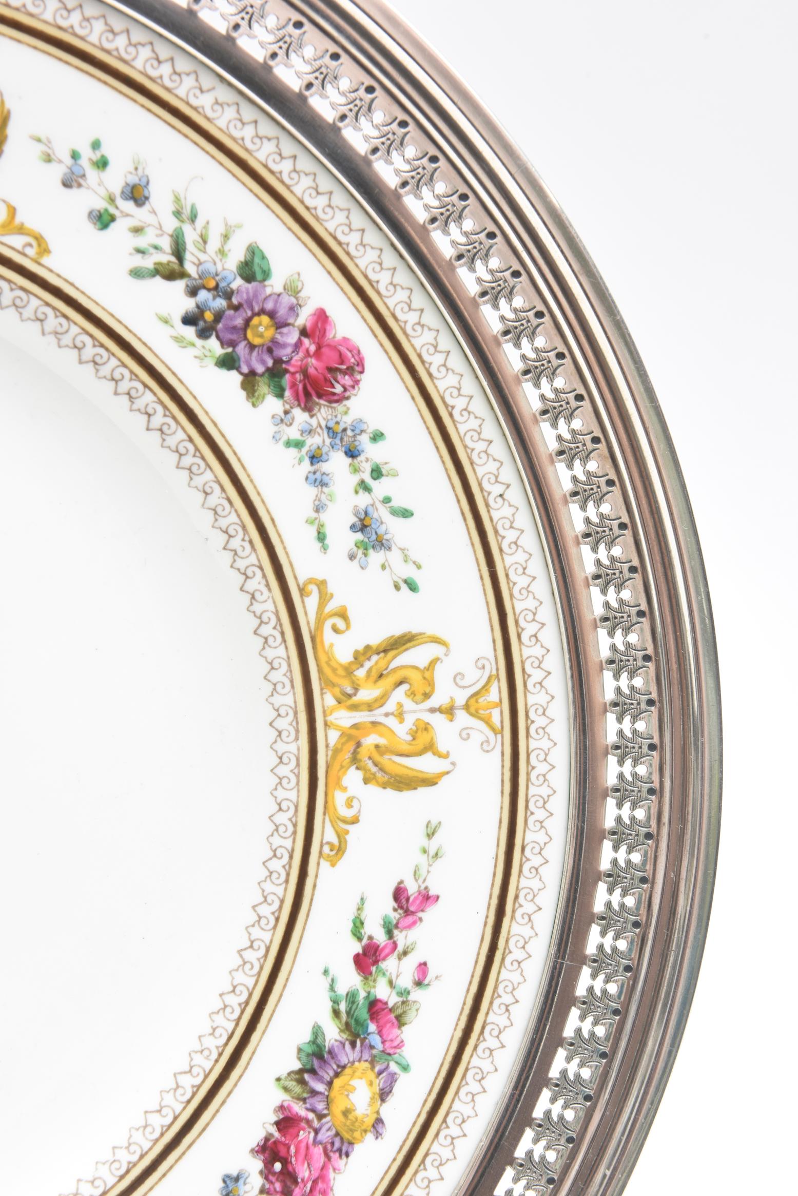 From Wedgwood England, we have a very handsome bone china set of 12 salad or dessert plates with a matching round serving platter. Fitted with a custom hand chased sterling silver collar and featuring one of Wedgwood's Classic enamel pattern