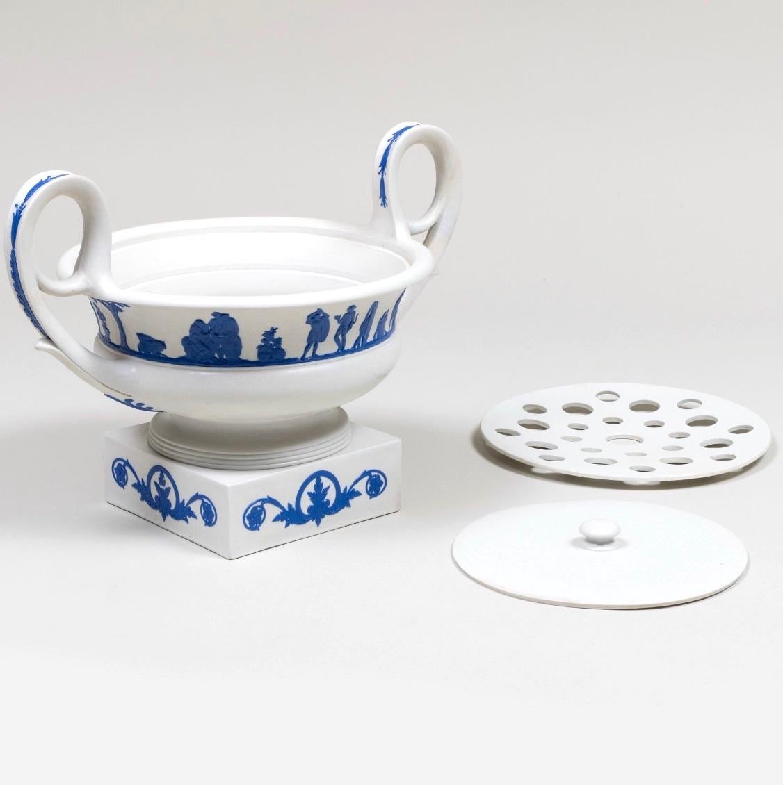 This exquisite antique Wedgwood Jasperware centerpiece vase, circa 1820, showcases the timeless elegance and craftsmanship that has made Wedgwood an icon of fine porcelain. Featuring a classic tree-piece design, the bough pot boasts a serene white