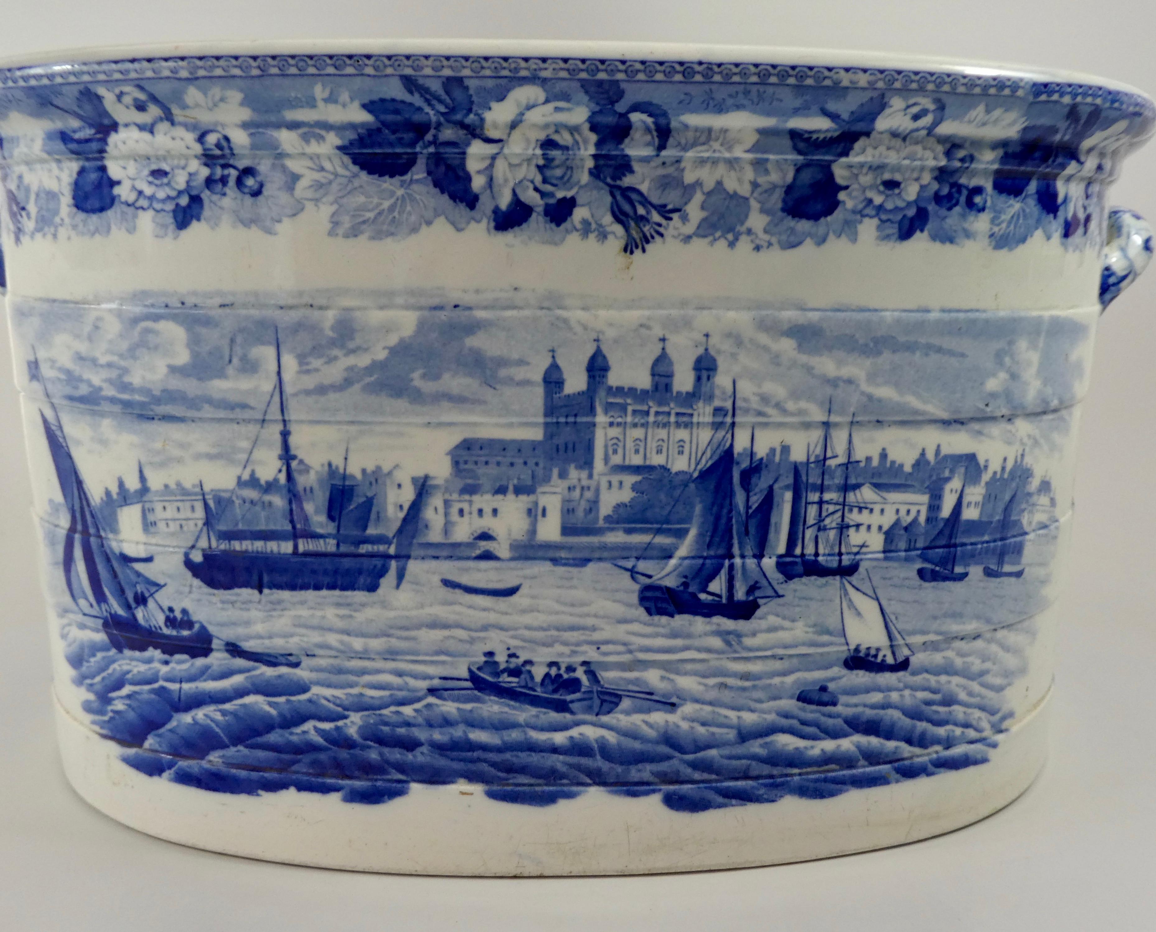 A fine and rare Wedgwood pottery foot bath, c. 1820. The foot bath moulded with bands, and printed in underglaze blue with views of the Tower of London and Traitors Gate, from the River Thames, beneath a Wild Rose border. Having twin handles, above