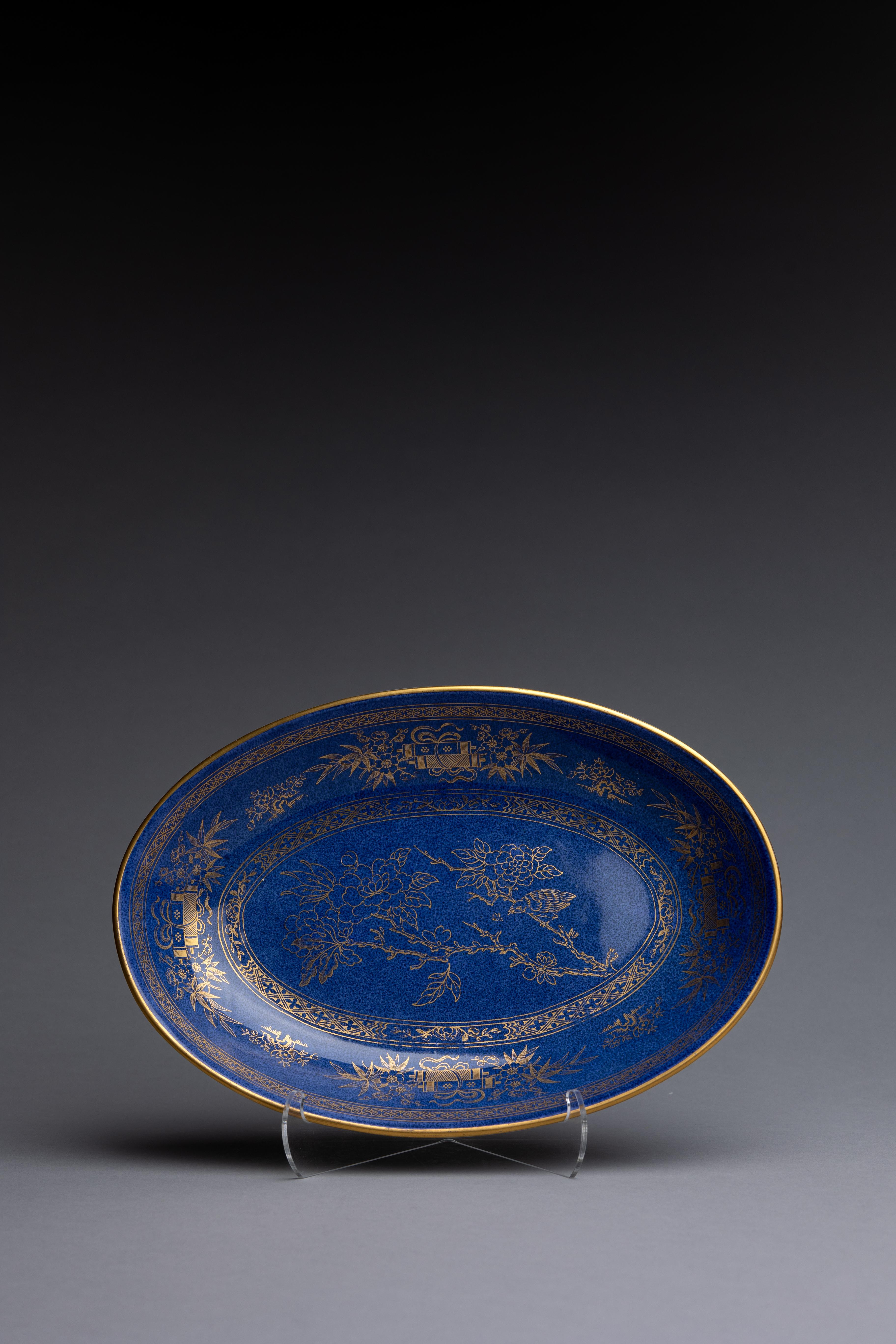 An early 20th century Wedgwood powder blue oval serving dish with gilded chinoiserie floral decoration.

The Wedgwood factory began experimentation to create powder-blue, or bleu soufflé, wares in the beginning of the 20th century. It took for its