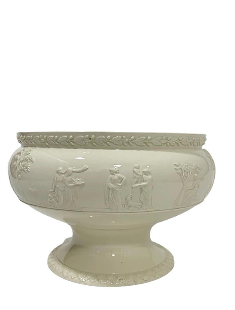 Wedgwood Queensware embossed footed bowl, England

A Wedgwood Queensware embossed footed bowl with Greek scene and gadroon patterned foot
Marked with Wedgwood's impressed mark, Made in England and letters P/J/8 and Mark Wedgwood Embossed