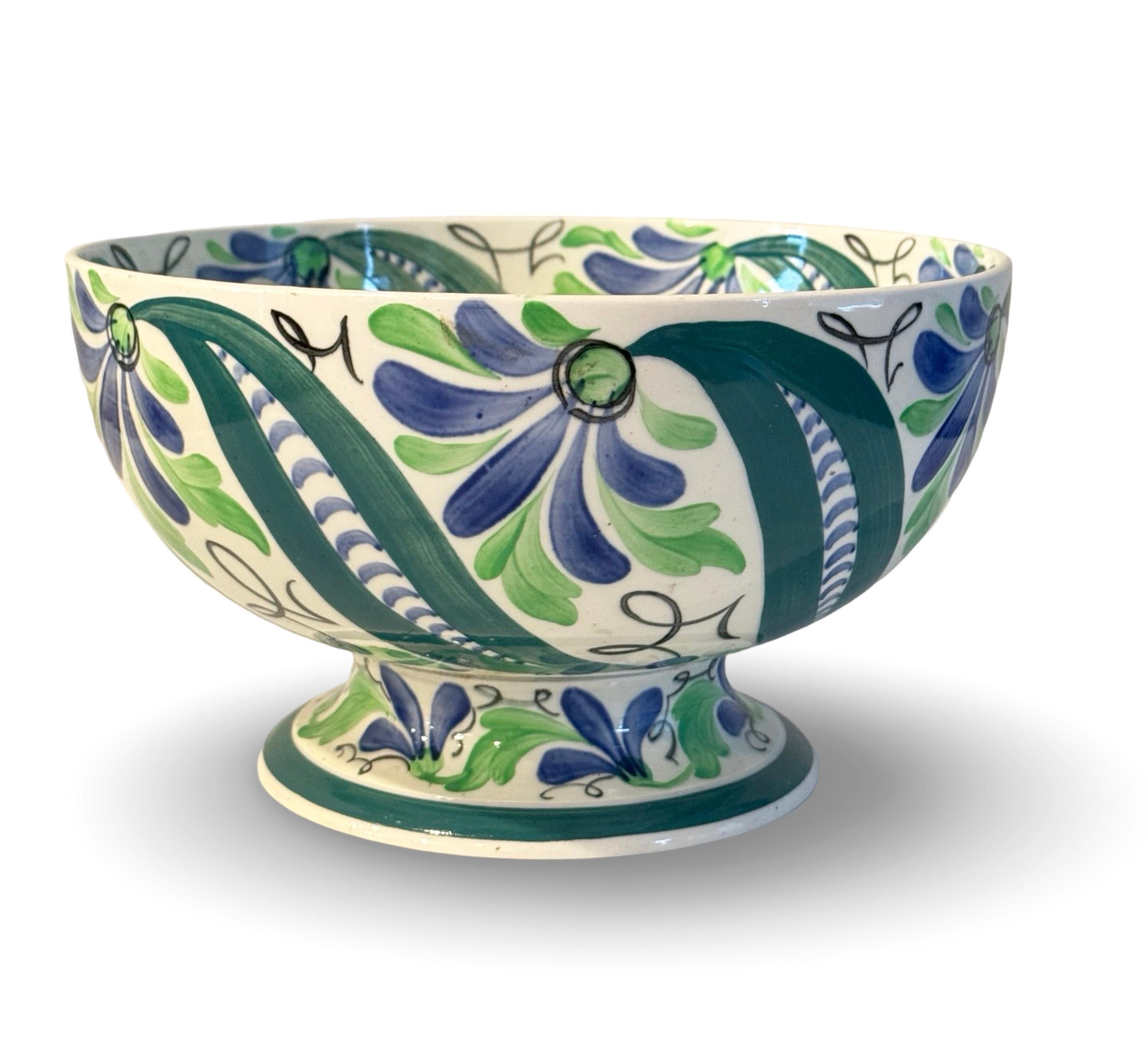 Bol à pied Queensware de Wedgwood, de la période Art Déco. Peint en vert et bleu avec un motif de feuillage stylisé, la base est imprimée Wedgwood, Made in England, avec des numéros de motifs peints, et divers autocollants de Collection. La taille