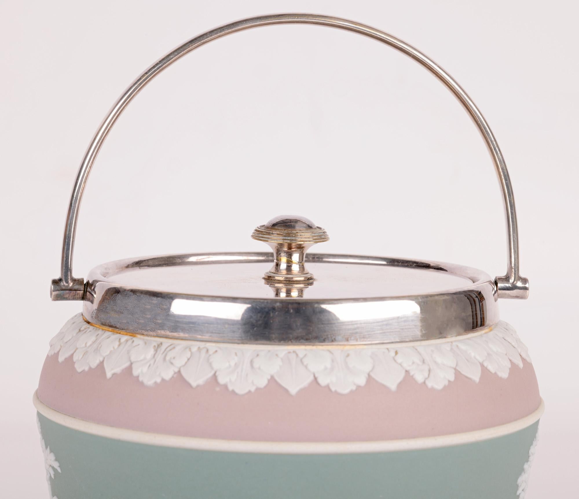A rare and very finely made antique Wedgwood tri-color jasperware biscuit jar applied with silver plated mounts dating from the 19th century. The stoneware jar stands raised on a narrow round foot and is of wide rounded shaped with a concave central