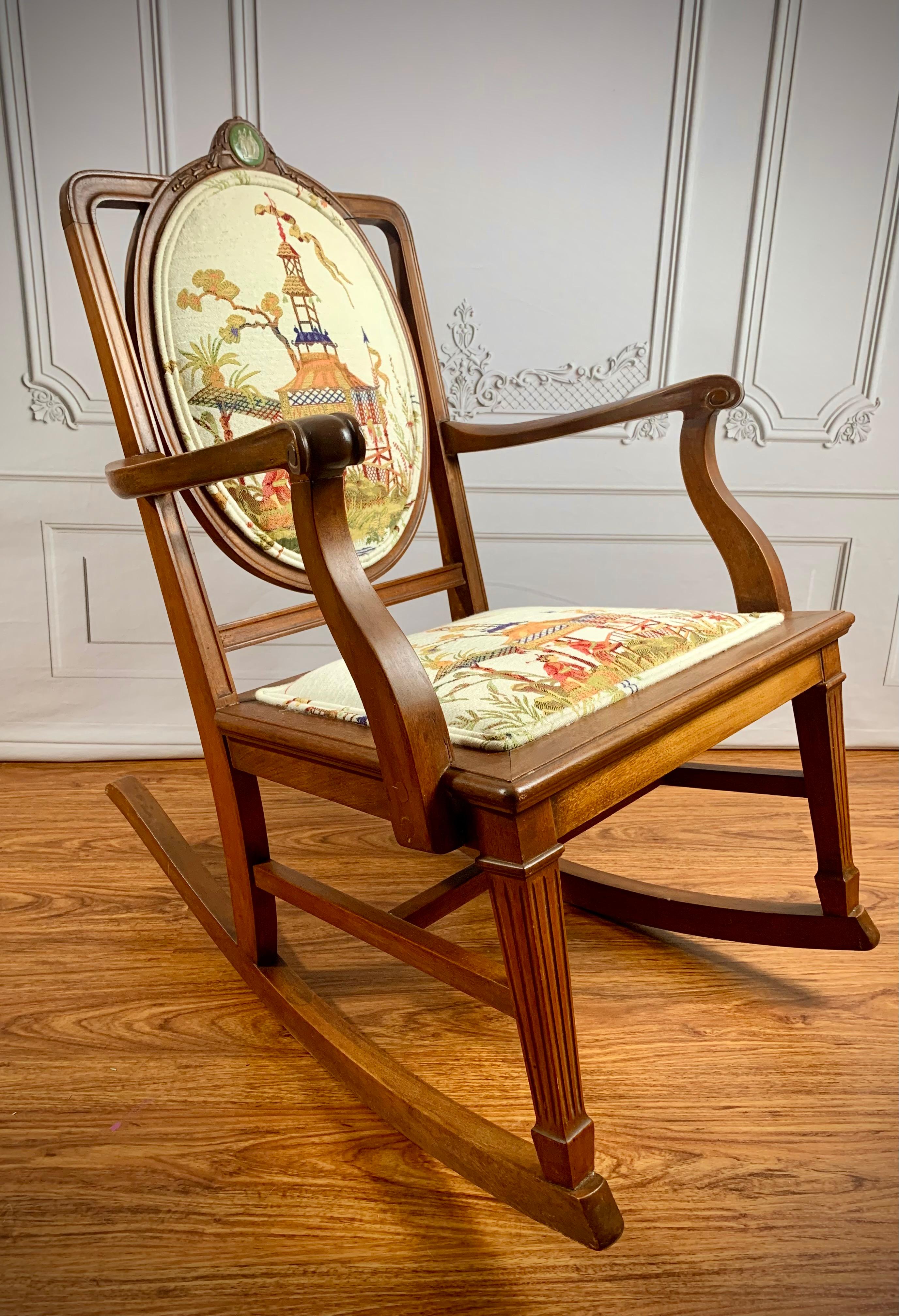 Late 19th century Neoclassical style hardwood rocker with hand-carved armrests, fluted legs, hand-lathed screws. 

Custom upholstery in a beautiful ivory linen featuring a woven Chinoiserie pattern. Crowned with a rare 18th century World Tour