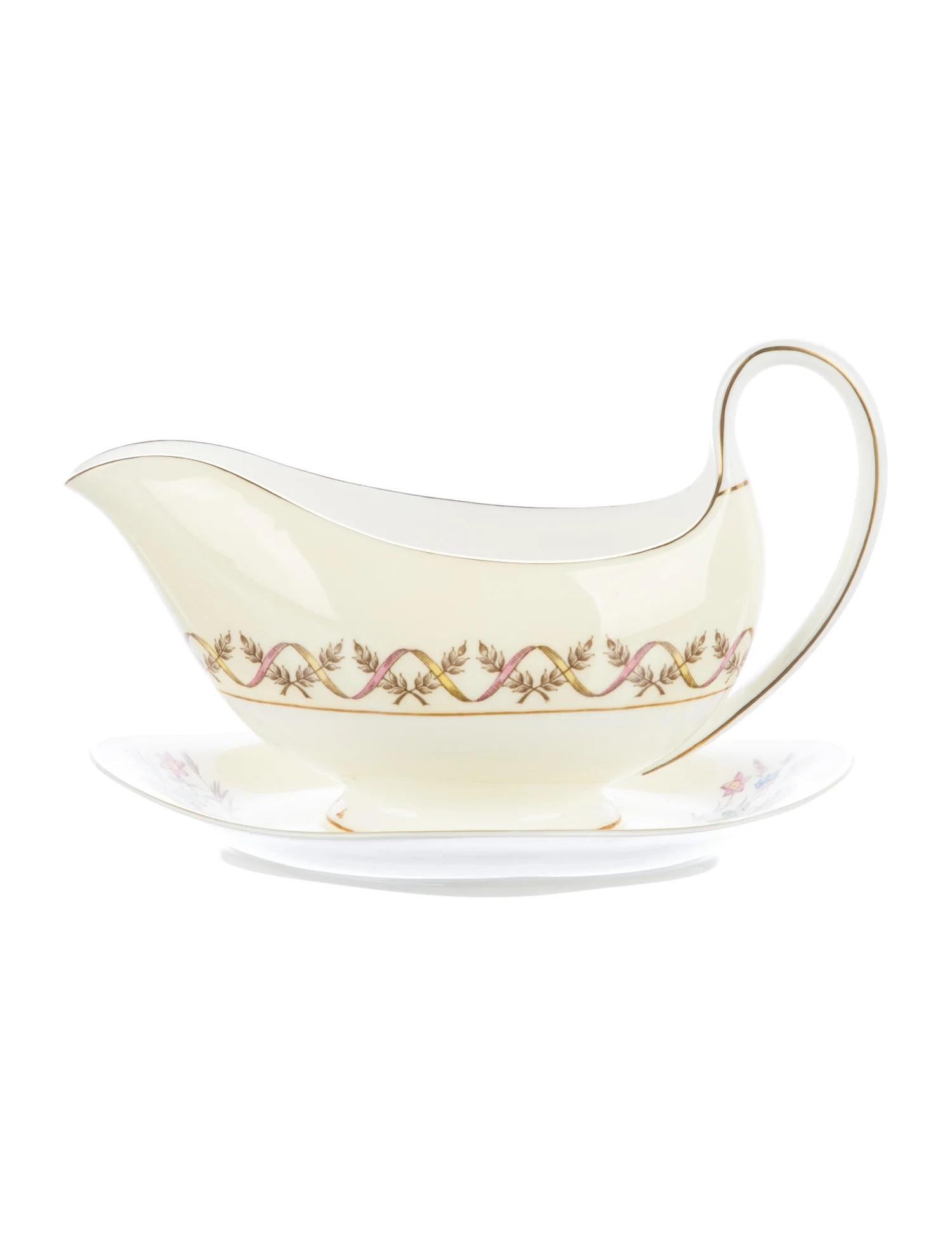 A set of 12 place settings (60 pieces) in the Wedgwood Sandringham pattern by Wedgwood.

Features a pink and yellow design with gilt rims, ribbon motif at edge, floral motif at center and brand stamp at underside. 

Includes the following 60