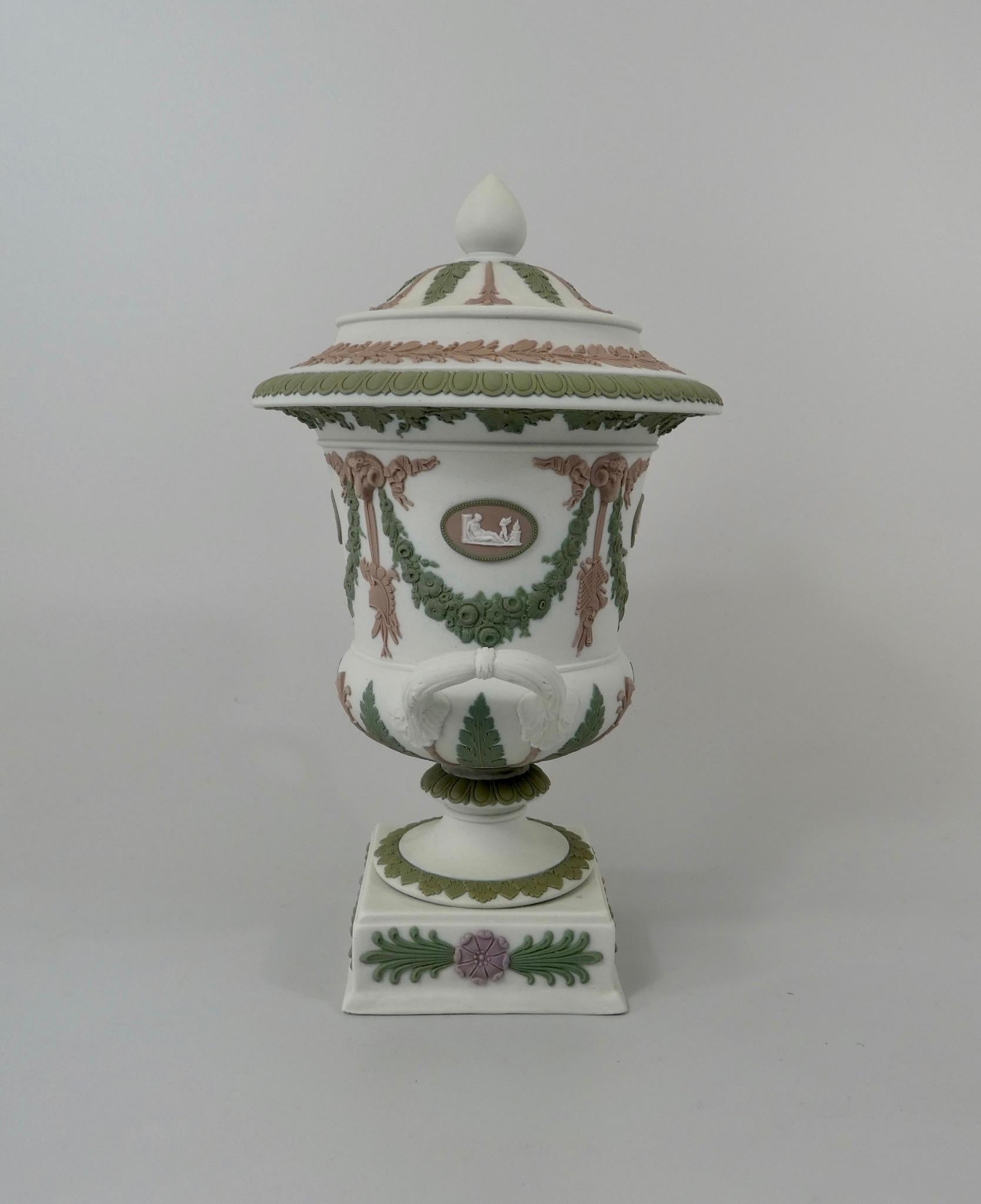 A fine Wedgwood ‘Three colour’ pottery vase and cover, circa 1900. The vase, sprigged with four lilac oval medallions, containing Classical figures, within flowering green swags, suspended from lilac rams heads, which also support hanging ribbons,