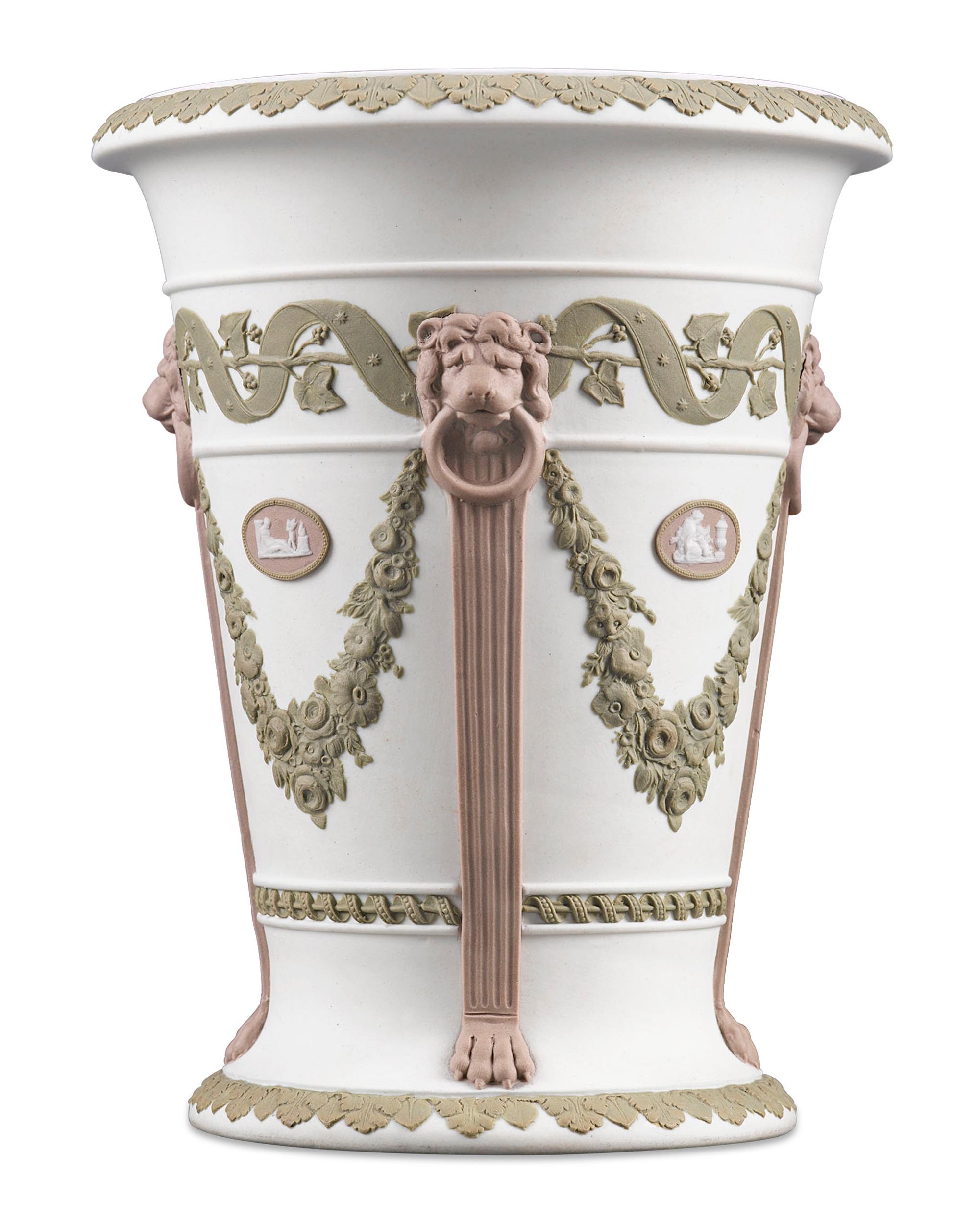 This sensational Wedgwood tricolor jasperware vase is truly a work of art. The exceptional and ornate vessel characterizes the Neoclassical Revival of the Georgian period. The gently flared design boasts lions’ head masks atop pilaster columns,