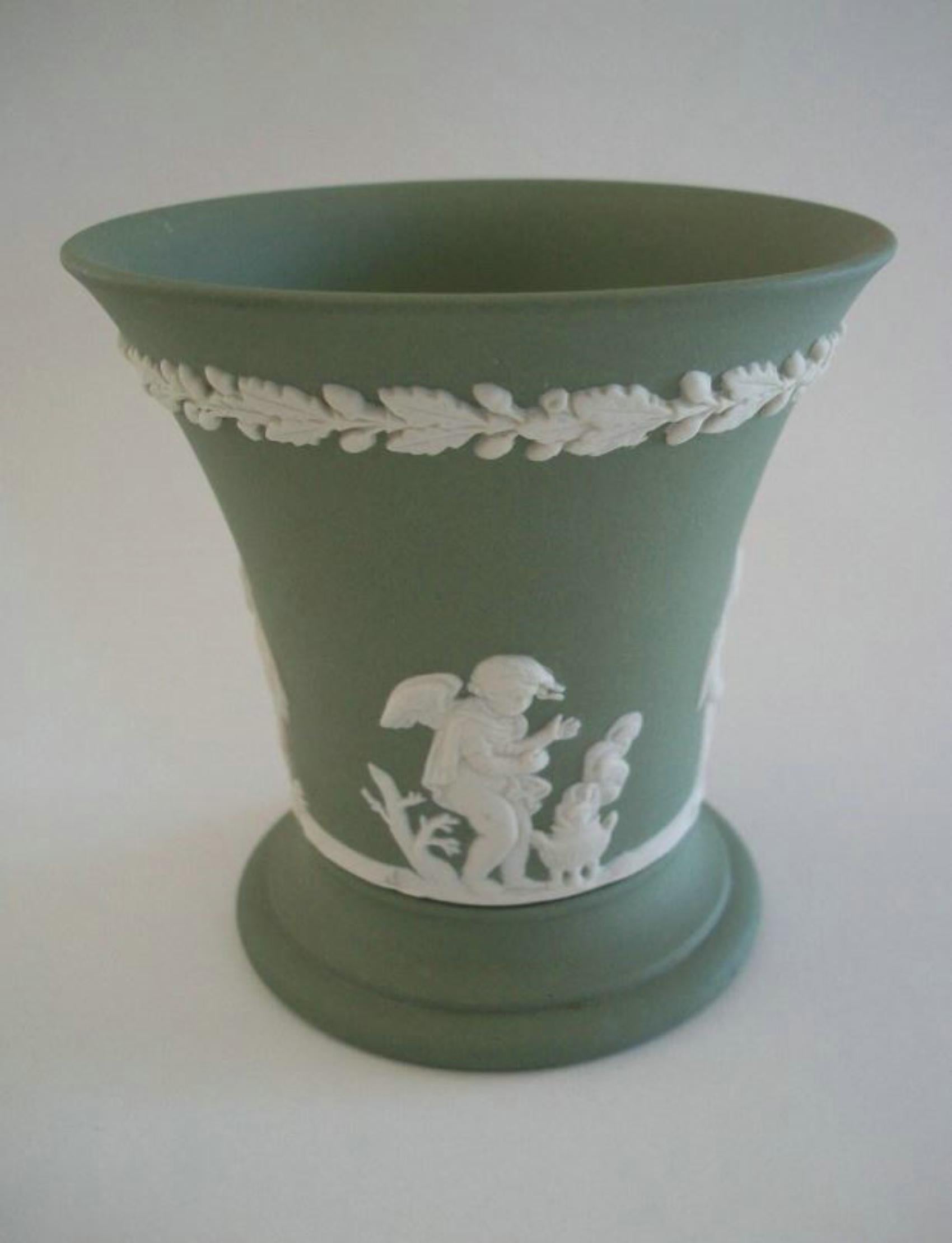 WEDGWOOD - Vaso 4 Stagioni in Jasperware verde d'epoca - raffigurante amorini in vignette separate con un bordo fogliare sulla parte superiore - finitura opaca - firmato sulla base - Regno Unito - fine del XX secolo.

Eccellenti condizioni vintage -