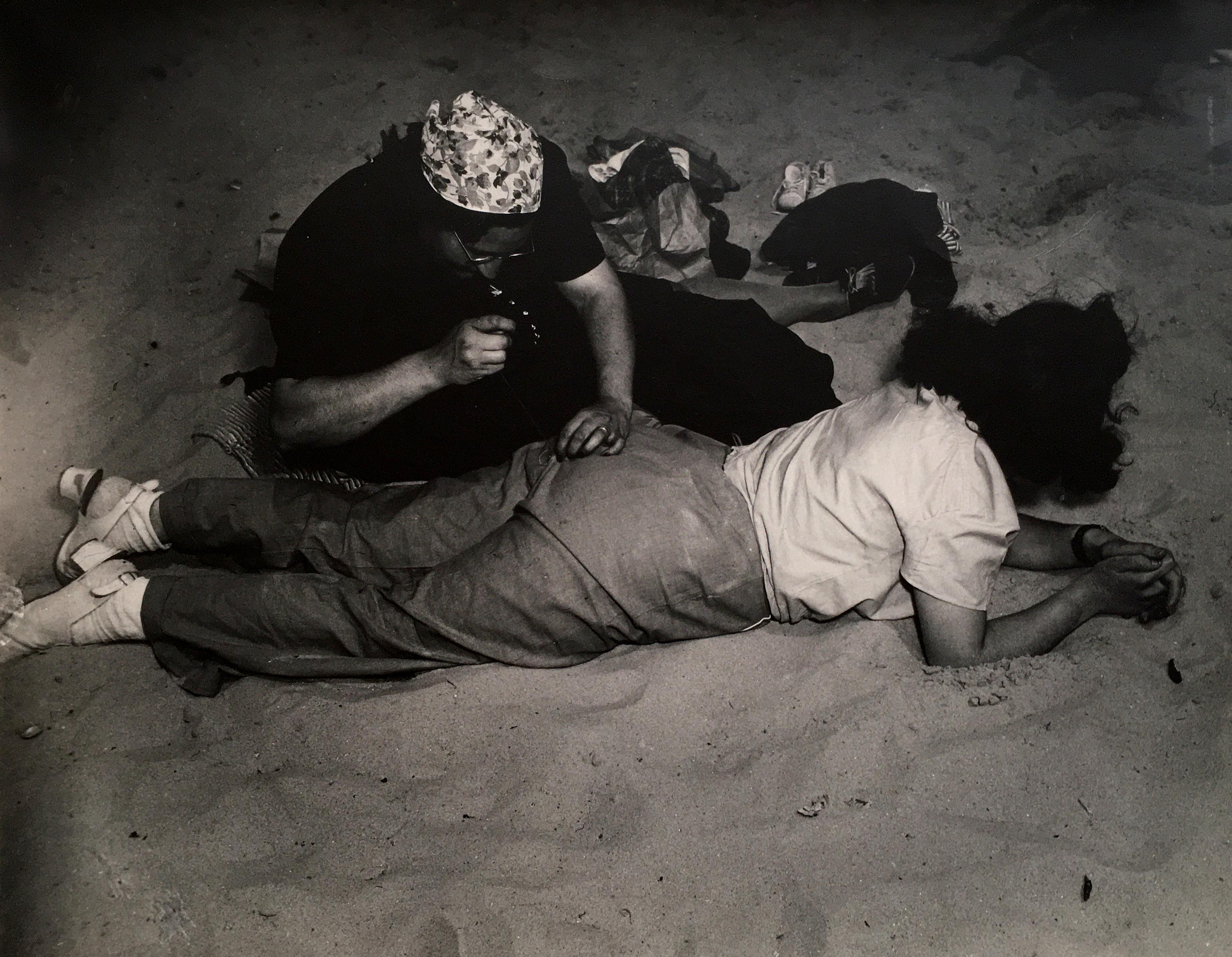 Weegee Portrait Photograph - Woman Sewing at the Beach