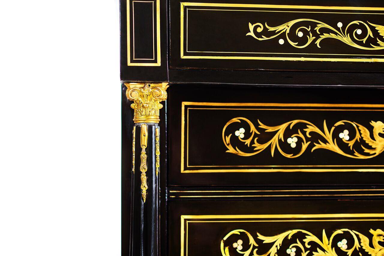 This cabinet of the Empire style, made of beech and fire wood, with seven drawers, marble top cover, metallic elements and pearly (nacre) intarsia is a special object with a representative function. The whole range of characteristic of this specific