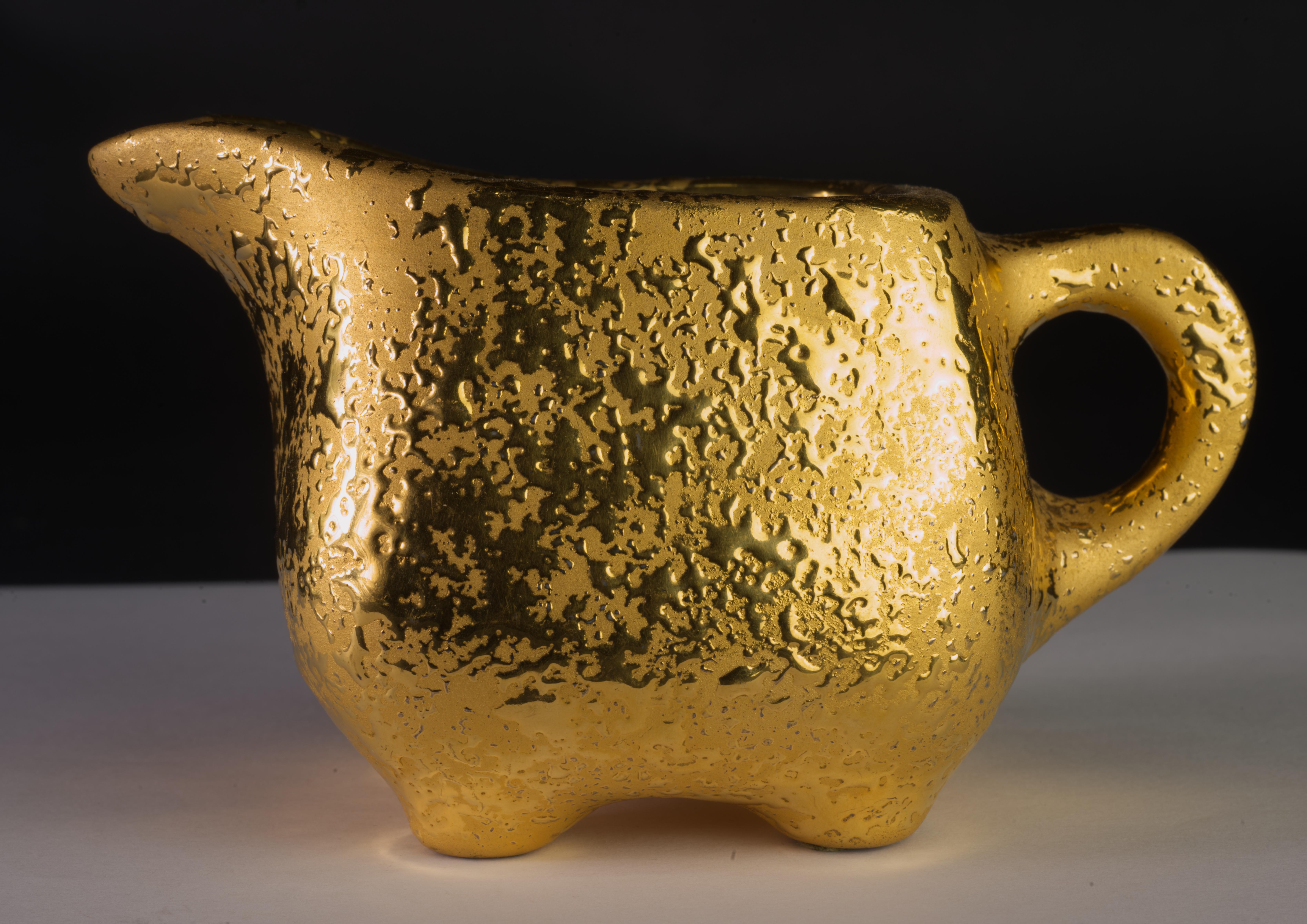  Le service composé d'un sucrier couvert, d'un crémier et d'un petit pichet à sirop ou d'une aiguière a été réalisé par le Dixon Art Studio avec la technique de l'or pleureur 22k. Le processus de l'or suintant s'est déroulé en plusieurs étapes, dont