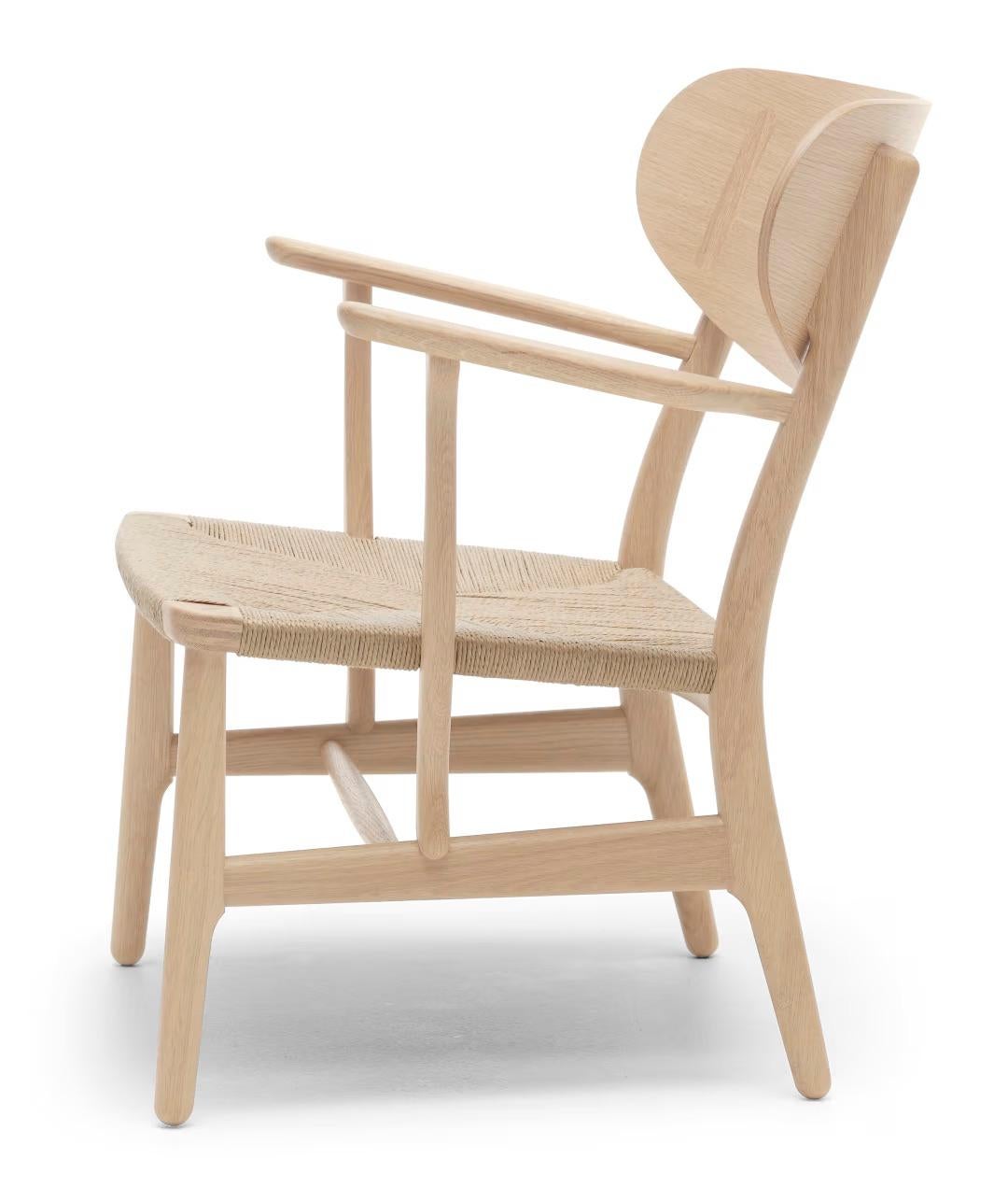 Wegner 'CH22' Stuhl aus Eiche, weiß, Öl und natürlicher Papierkordel, für Carl Hansen & Sohn

Die Geschichte der dänischen Moderne beginnt im Jahr 1908, als Carl Hansen seine erste Werkstatt eröffnet. Sein Engagement für Schönheit, Komfort,