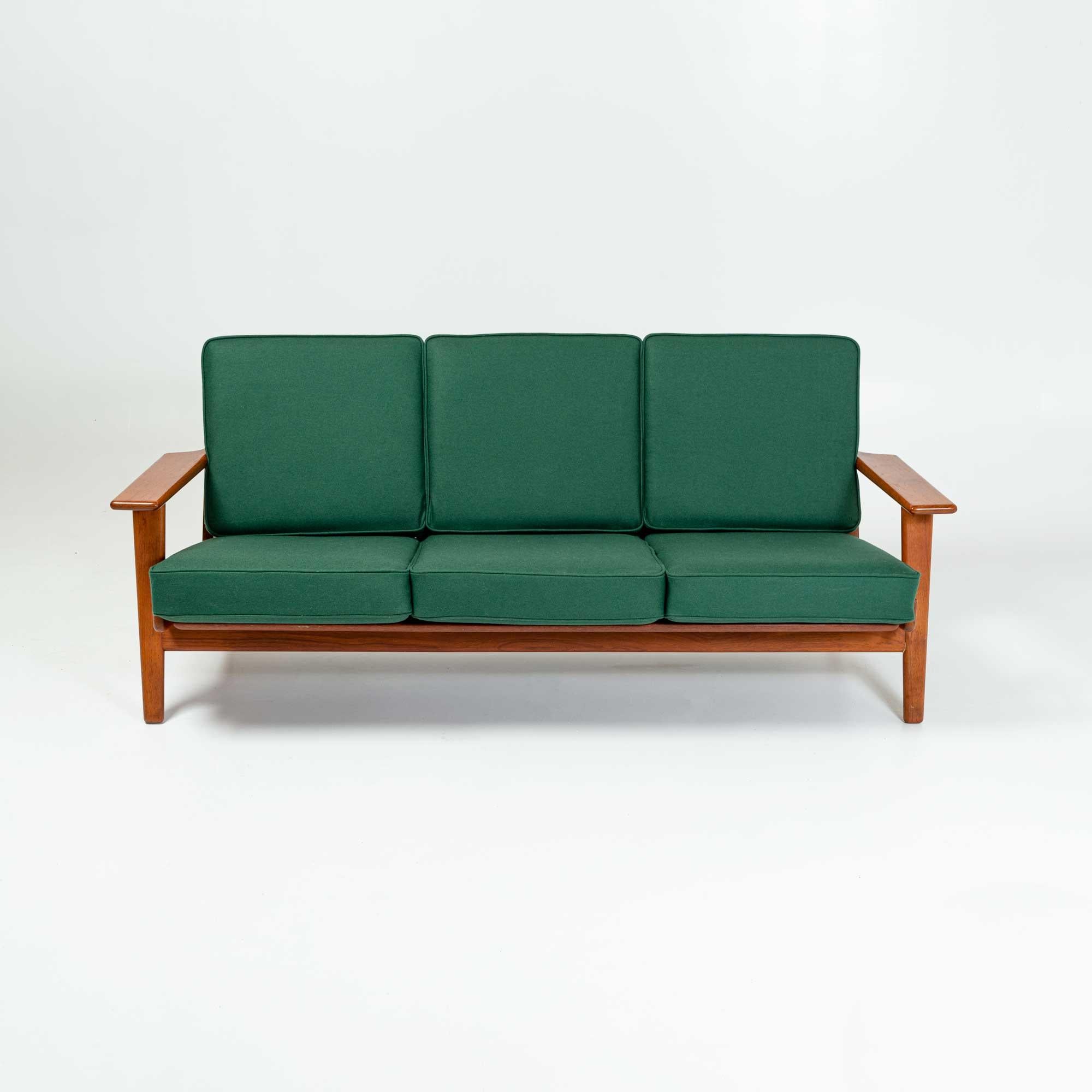 Hans Wegner GE-290 sofa designed in 1953 and produced by Getama, in Solid Teak Frame. The original box spring cushions have been completely restored, spring retied, foam replaced and newly upholstered in Danish Green wool.