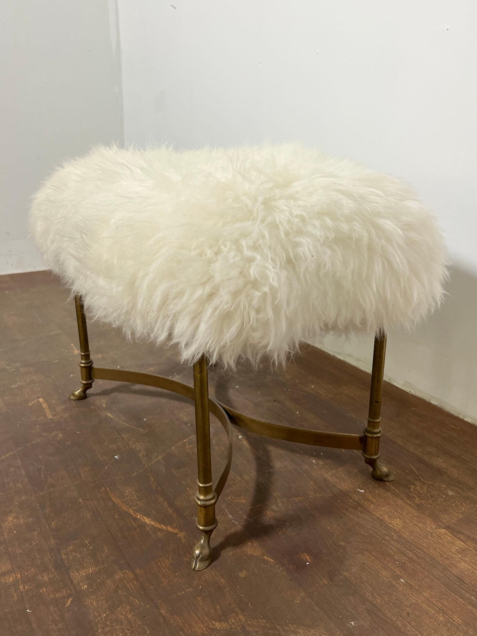 Vintage brass bench or stool with hooved feet, upholstered in Mongolian lambs wool. Labeled Weiman/Warren Lloyd.