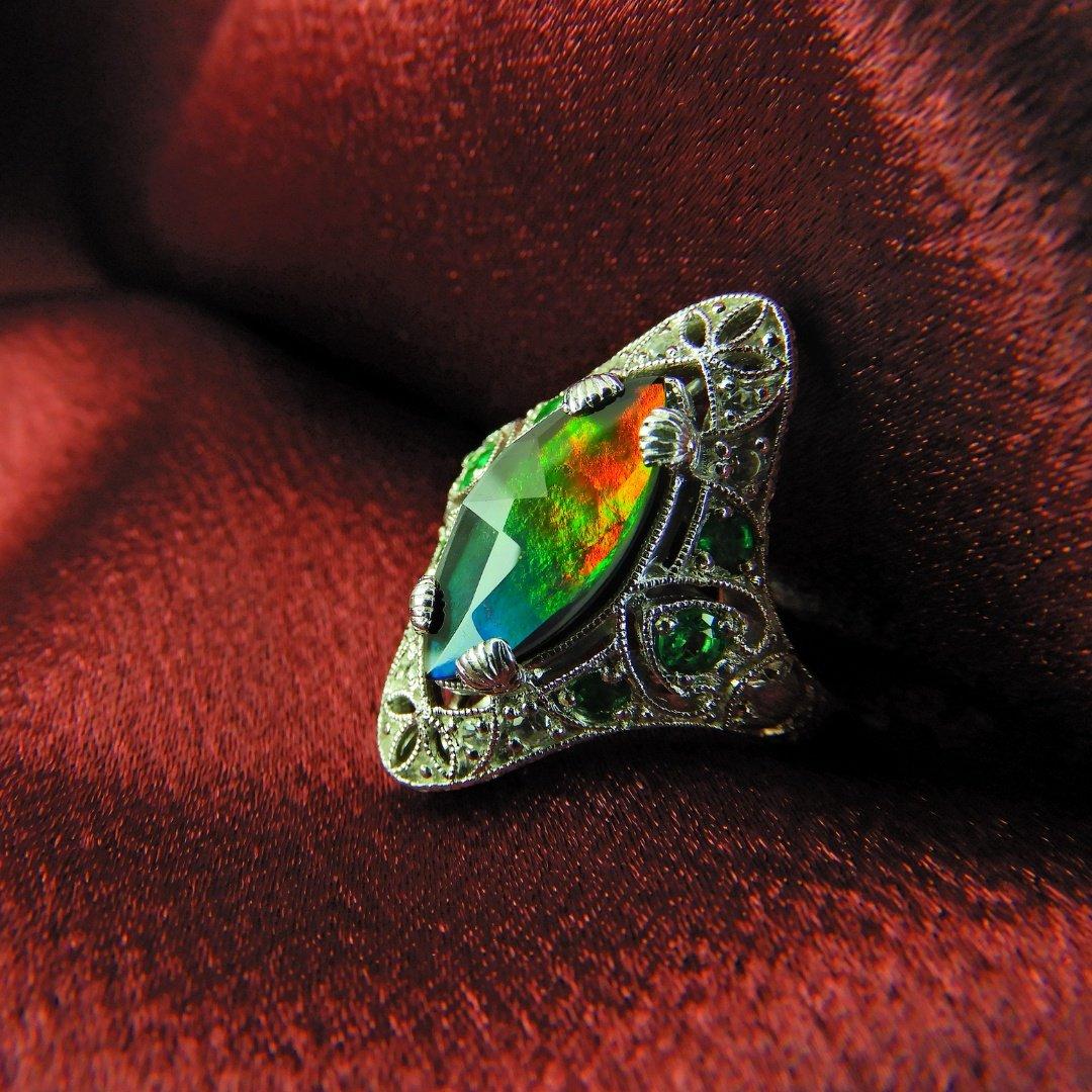 Bob Weinman designed, A grade 16mm x 7mm marquise Ammolite set in sterling silver accented with 0.40CT panjshir emeralds and 8 diamond cut white zircon.

Since 1979, KORITE has been the home of superior Ammolite, inspiring the world with the rarity