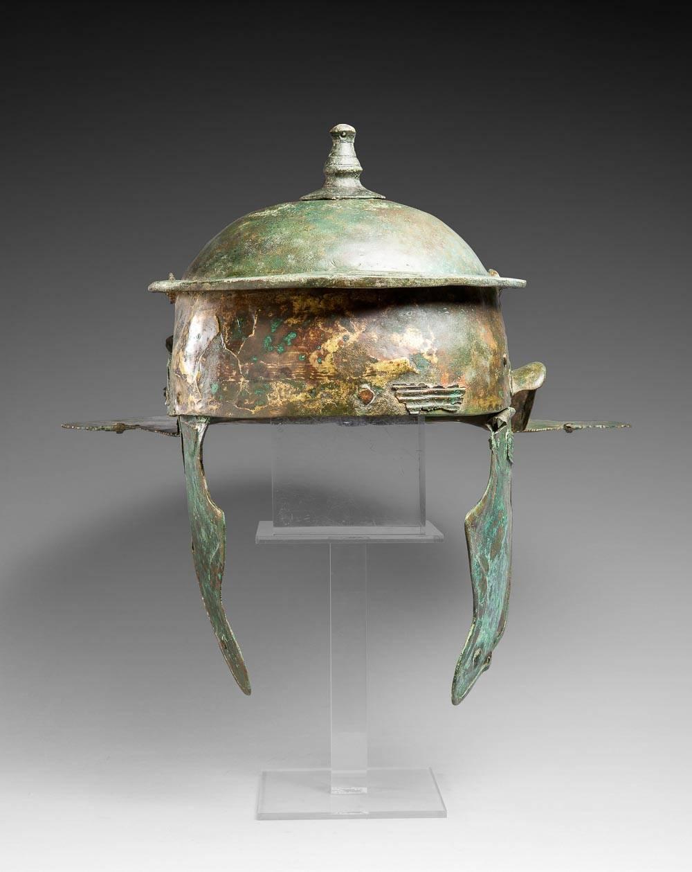 Helm Typ Weisenau
Römische Kunst, 1. bis Mitte des 2. Jahrhunderts.
Bronze.

Abmessungen: 18,7 x 21,7 cm.

Provenienz : Privatsammlung von Herrn G.G., Paris;
Ehemalige Sammlung Axel Guttmann (AG 502), 1989 in London erworben.
Gekauft 1989 in London.