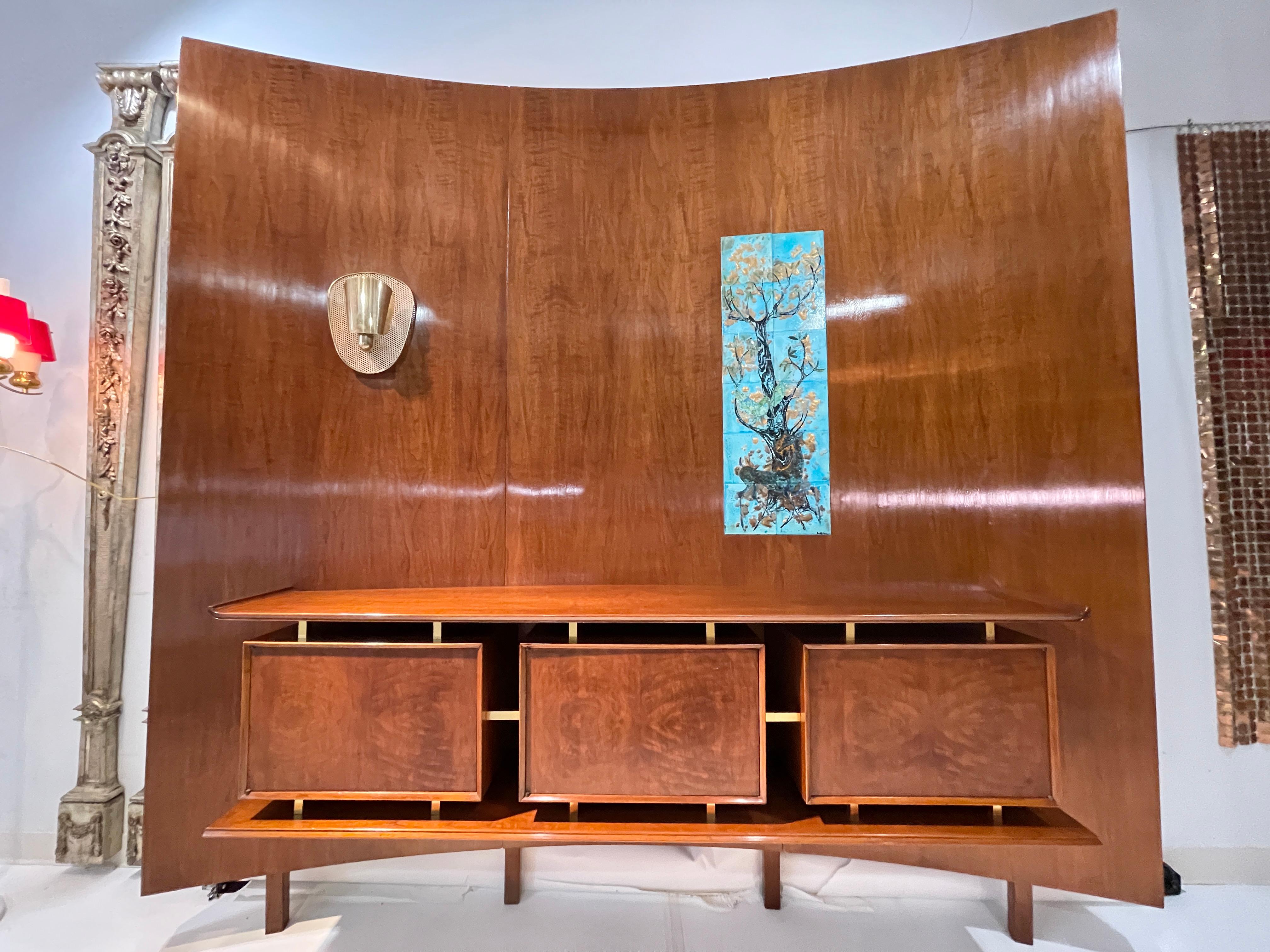 Hans Weiss (1900 to ?) and William Basser (1900 to 1958) of Weiss & Basser interior designers, New York, NY curved walnut wall unit mounted with floating sideboard consisting of three cabinets apparently supported by brass standoffs between an upper