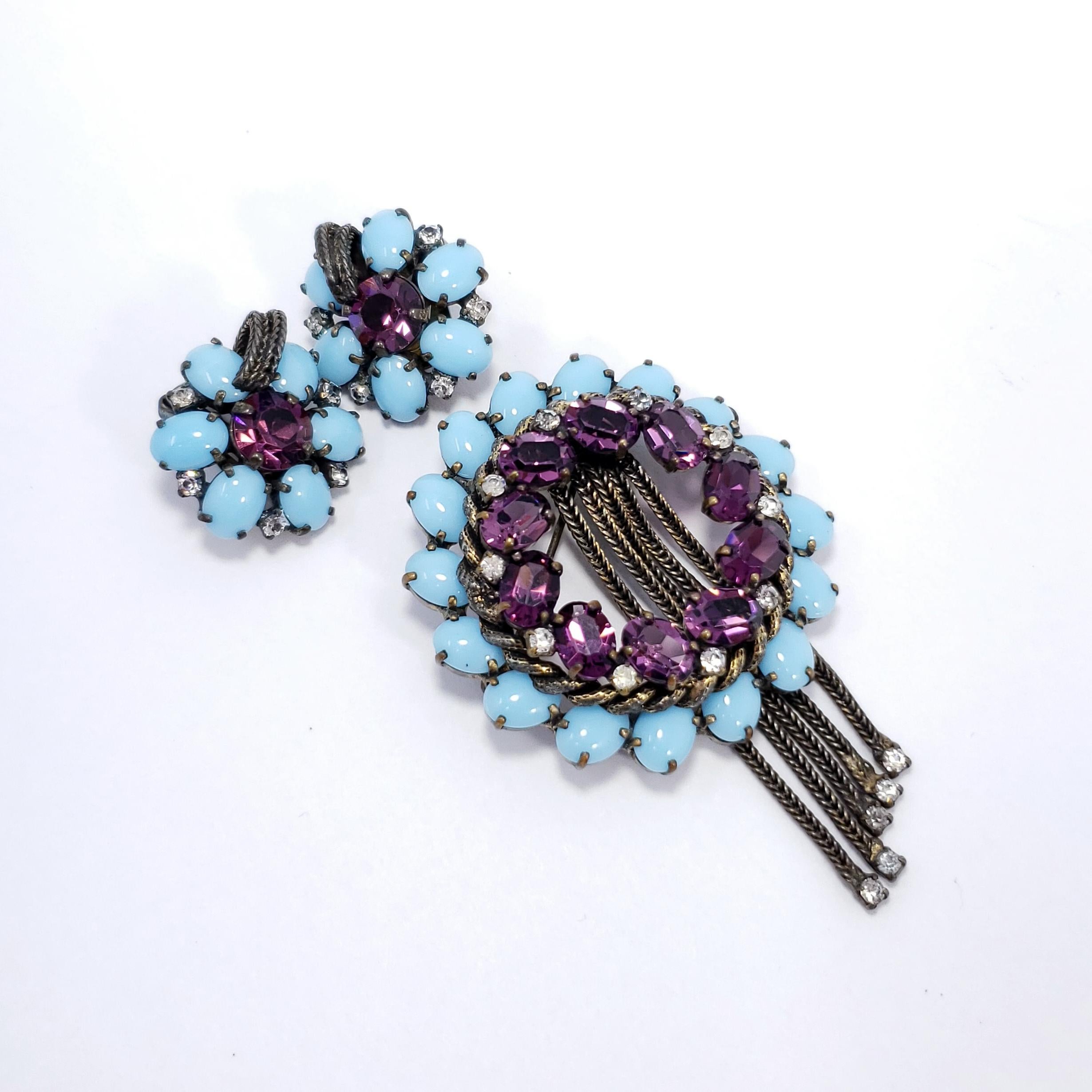 Vintage Weiss brooch and clip on earrings. A floral-themed collection, featuring a dazzling display of turquoise cabochons and amethyst crystals prong-set in a brass tone setting.

Brooch: 1.75 inches diameter
Earrings: .85 inches diameter 