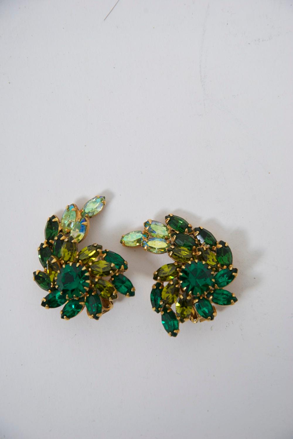 Weiss vintage clip-on earrings featuring two shades of green crystals, emerald and pale green of marquise form, their crescent shape centering a larger round emerald stone. The earrings complement the contour of the ear. Signed 