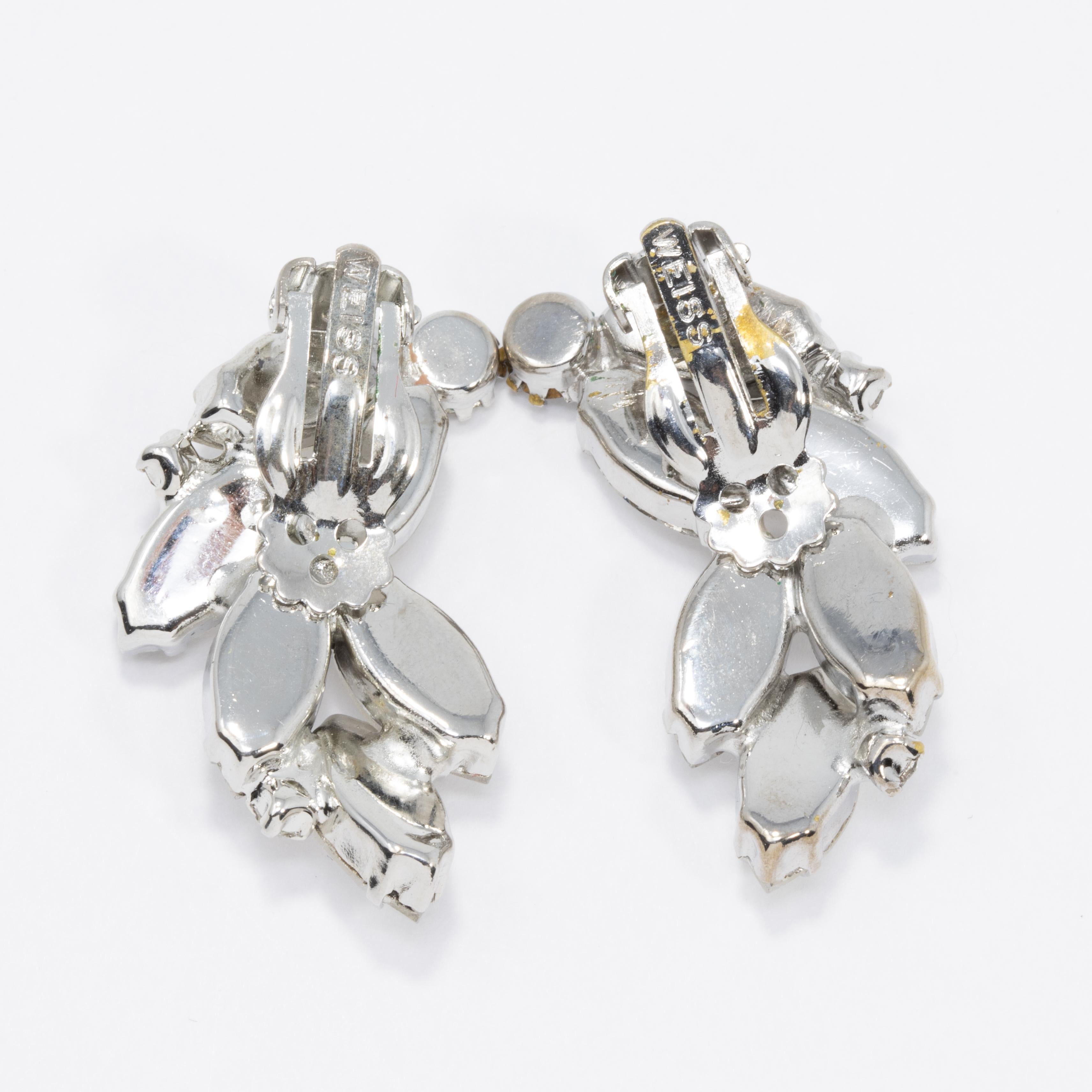 A stylish pair of vintage earrings, featuring  round and marquise-cut clear crystals on a silvertone setting.

Hallmarks: Weiss
