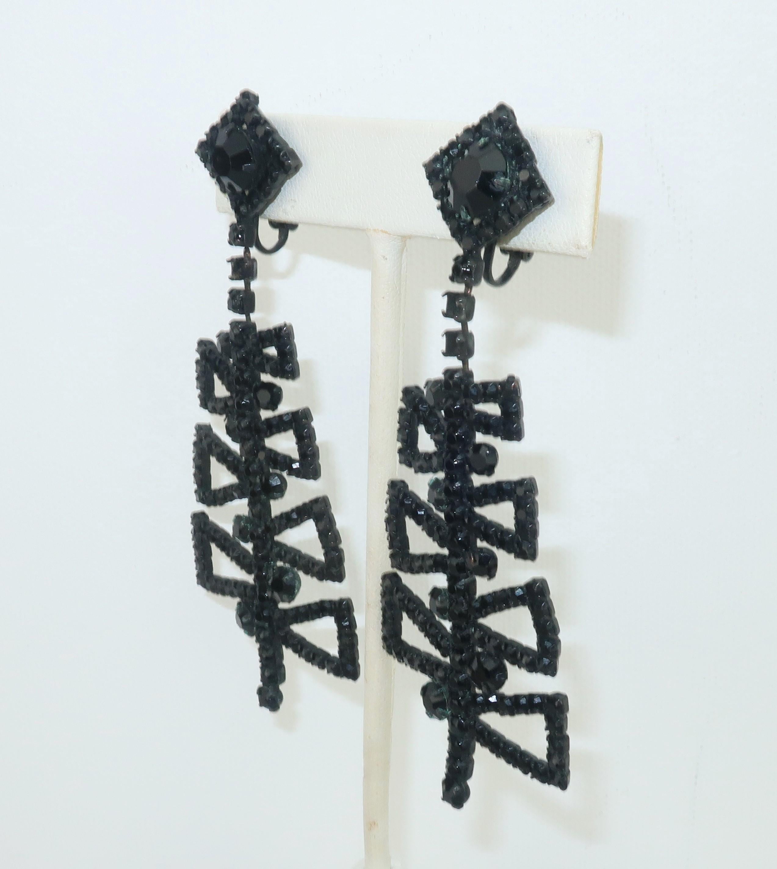 1960's Weiss screw back clip on dangle earrings with a mod geometric design in faceted black rhinestones and a black metal setting.  The perfect mod accessory for a period perfect look!
CONDITION
The earrings are in good to fair condition with three