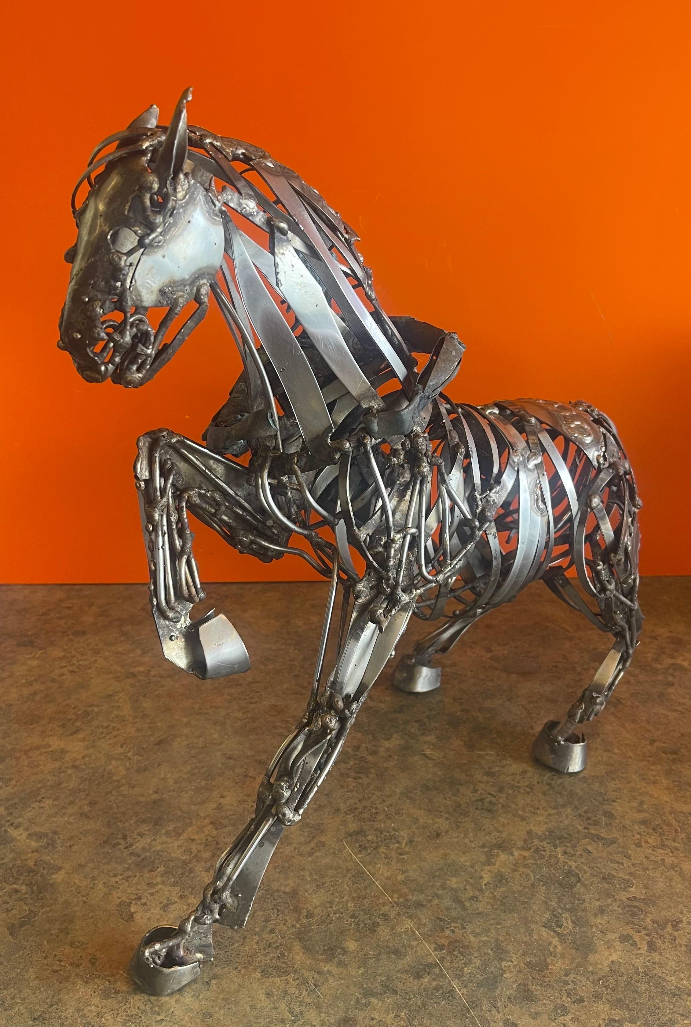 A wonderful welded stainless steel and bronze rider and horse sculpture in the style of Jiang Tie-Feng, circa 1980s. The piece has a fabulous look and patina and is signed on the back of the horse (very difficult to make out the signature). The