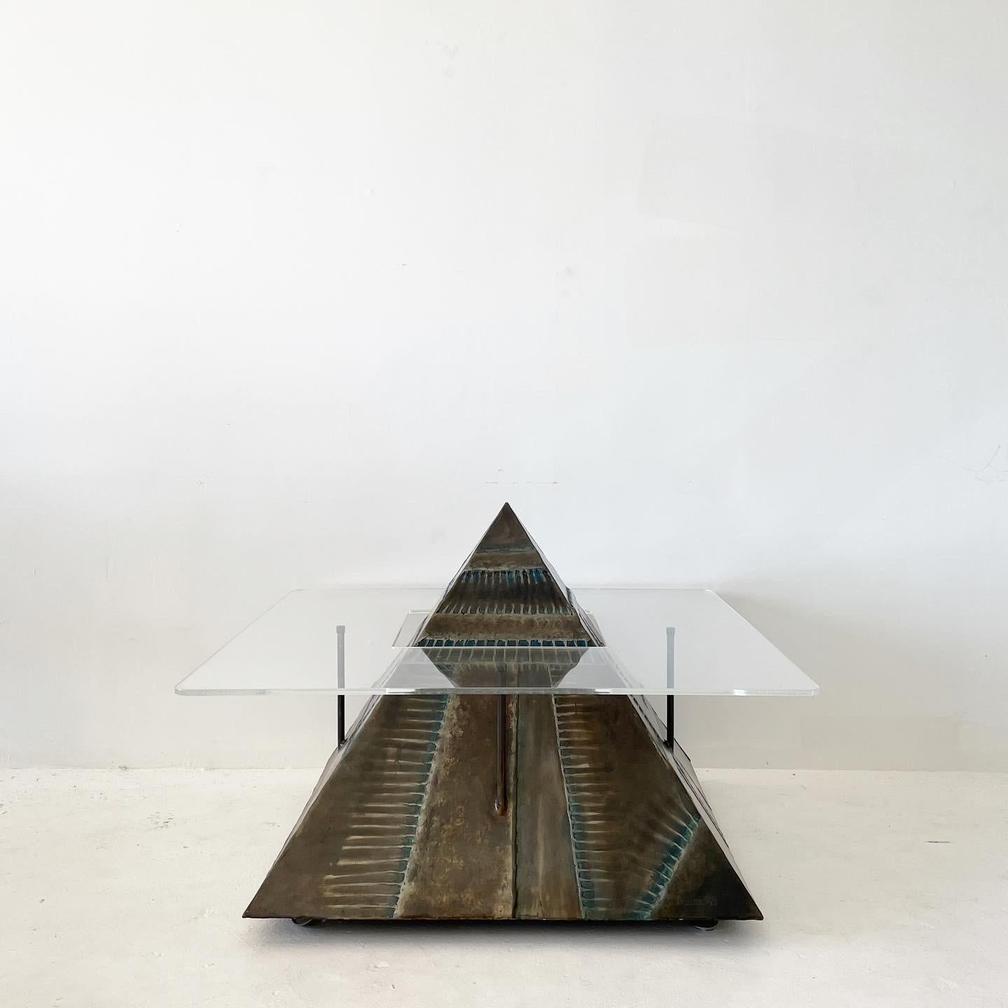 One of a kind, welded metal levitating pyramid coffee table made by a local LA artist. The surface of the sculpture is textured and a burnished bronze finish with some turquoise undertones.

Wrap around lucite table top is 3/4