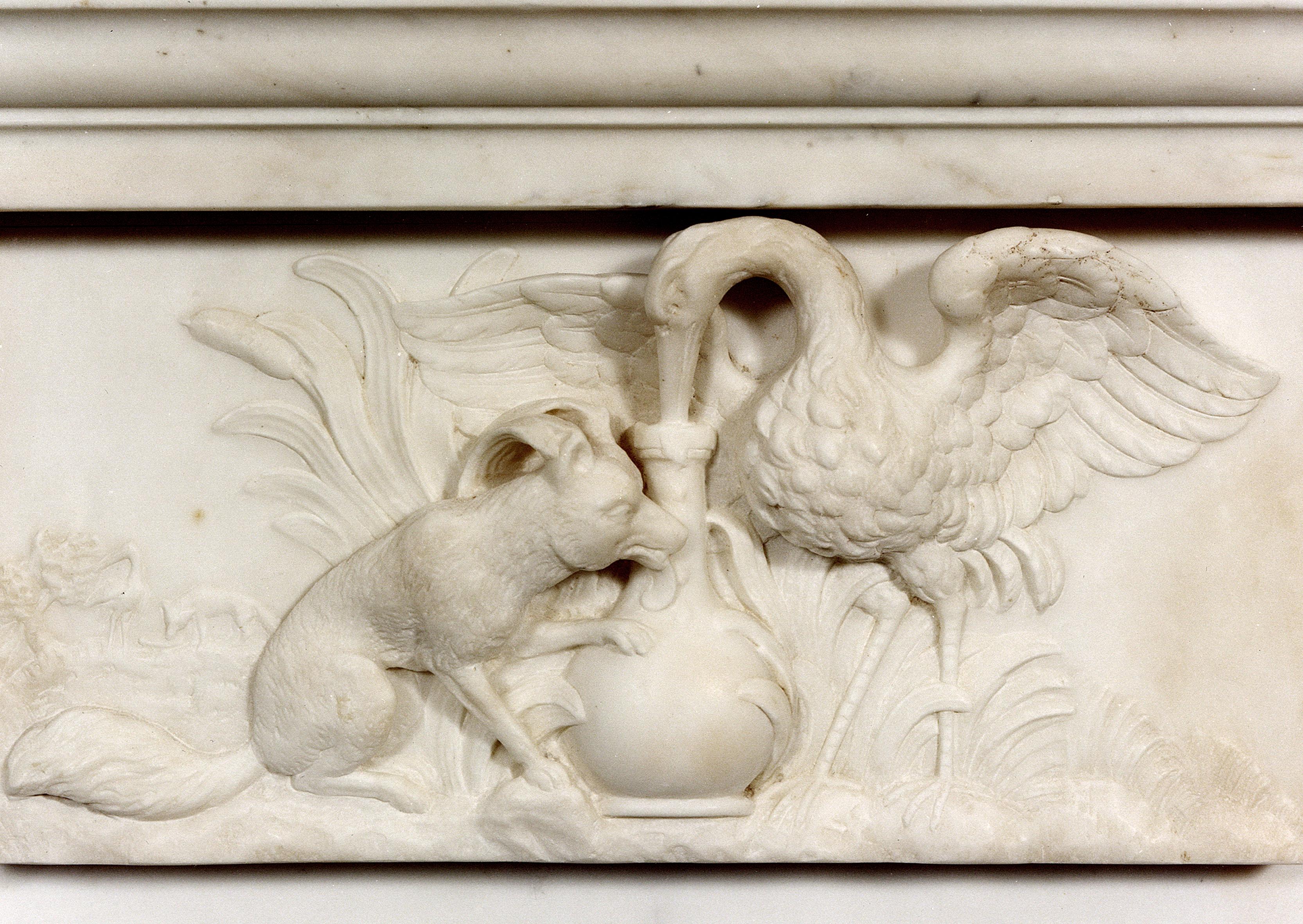 An unusual English marble fireplace with beautifully carved Aesops fable centre panel depicting the story of the Fox and the Stalk. The frieze with arched and dart detailing, with sweeping moulded bracketed jambs, 19th century with a Georgian