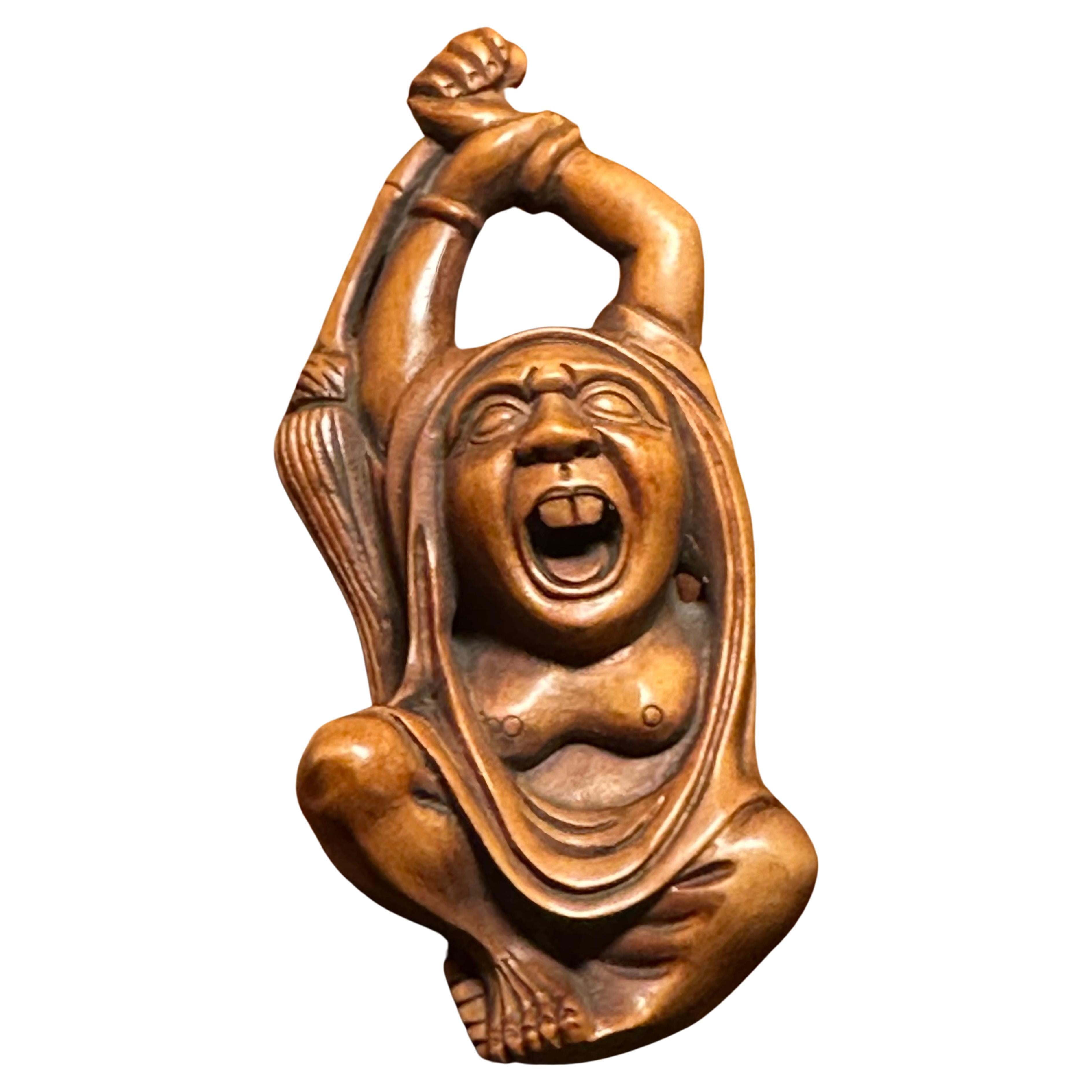 A well-carved Japanese boxwood netsuke of Daruma holding a whisk broom over the head by Ishikawa, circa 1940s.  The netsuke is in very good vintage condition, measures 1.375