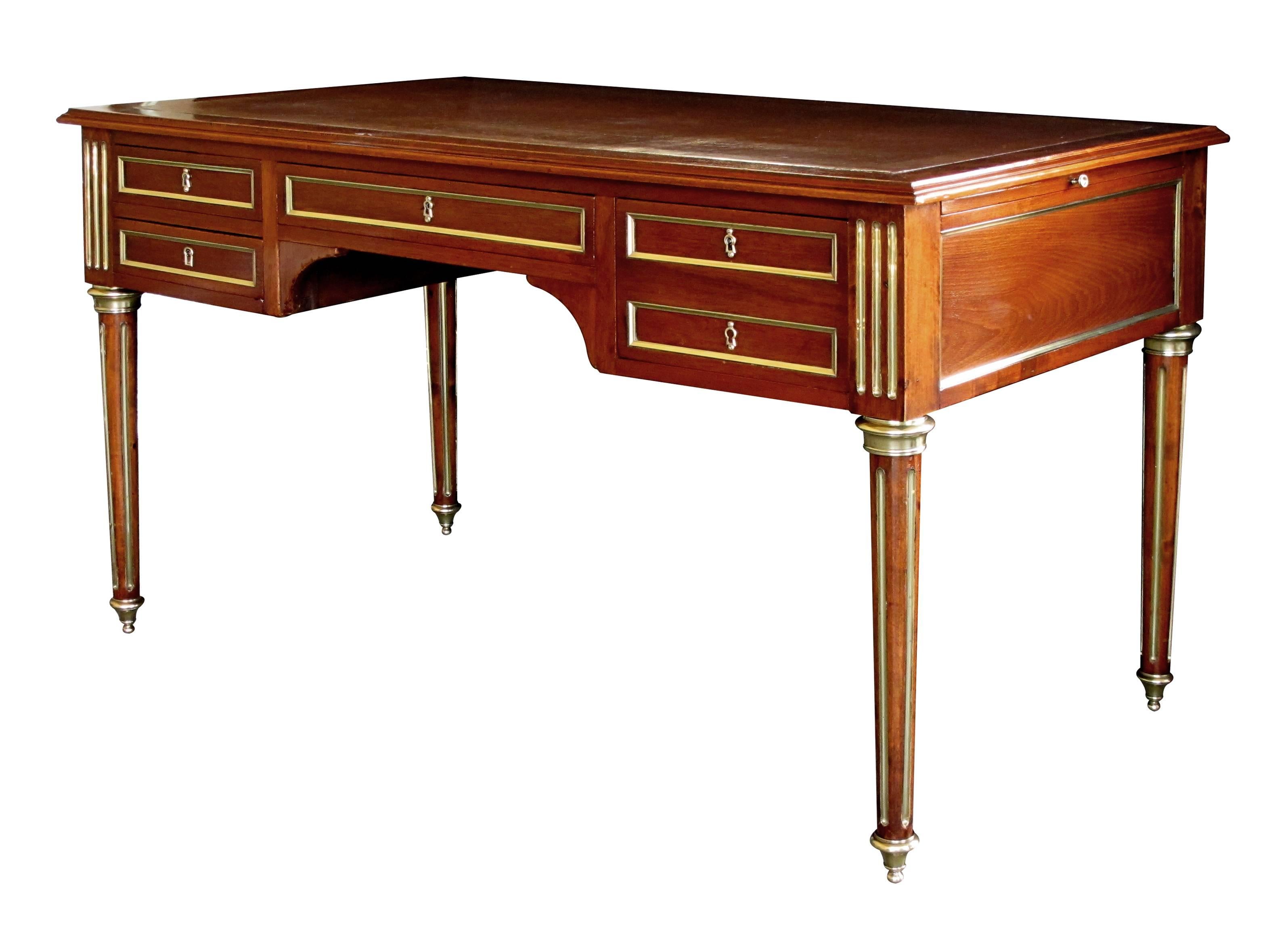 A beautiful and well-crafted French Louis XVI style mahogany four-drawer writing desk with leather top and brass mounts; this truly elegant and good quality bureau plat with tooled russet leather top above brass-mounted drawers; the sides with