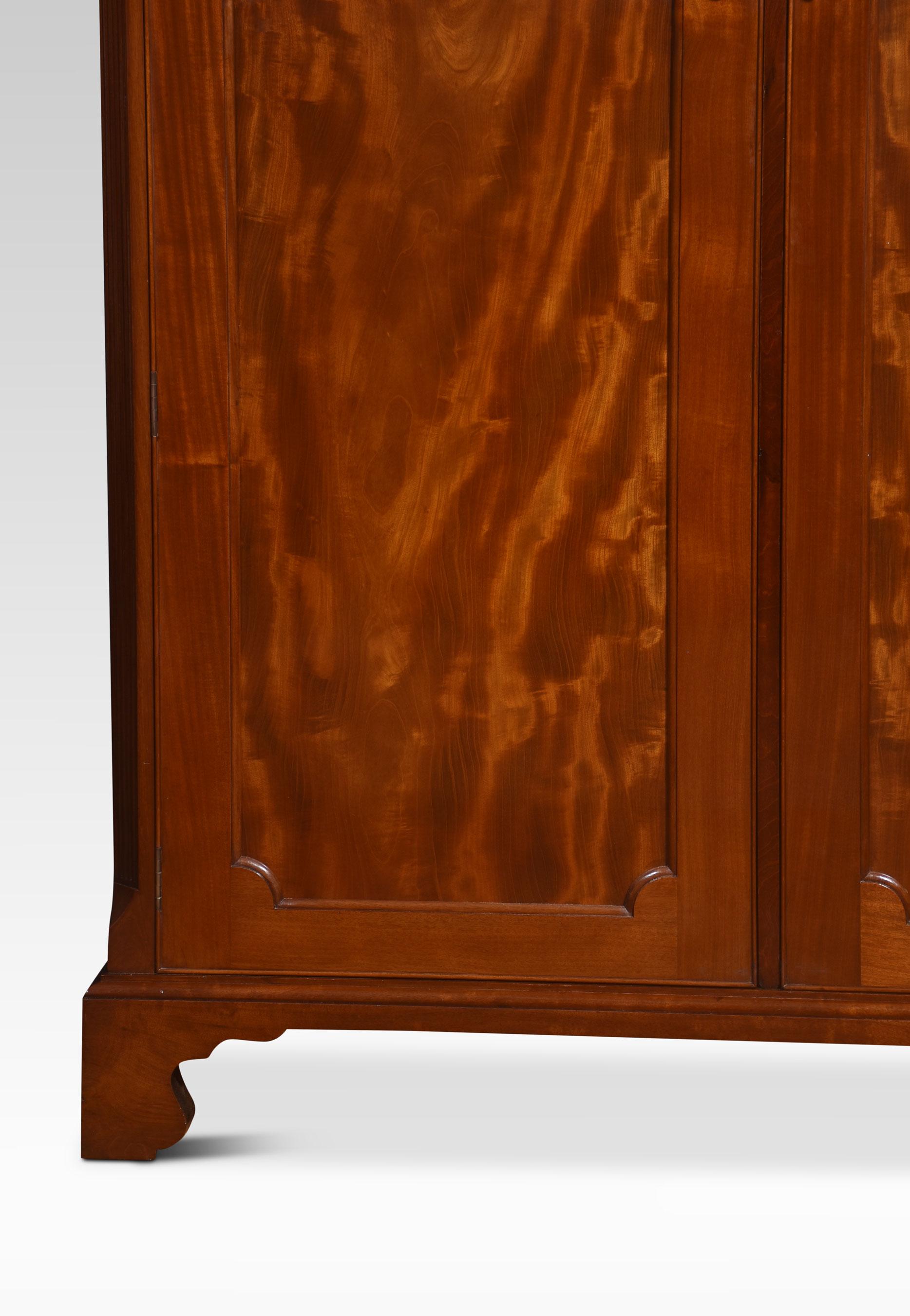 Mahogany wardrobe, the carved moulded cornice above two well figured mahogany panelled doors opening to reveal large hanging area with shelves above. All raised up on bracket feet.
Dimensions
Height 77.5 Inches
Width 53.5 Inches
Depth 26 Inches