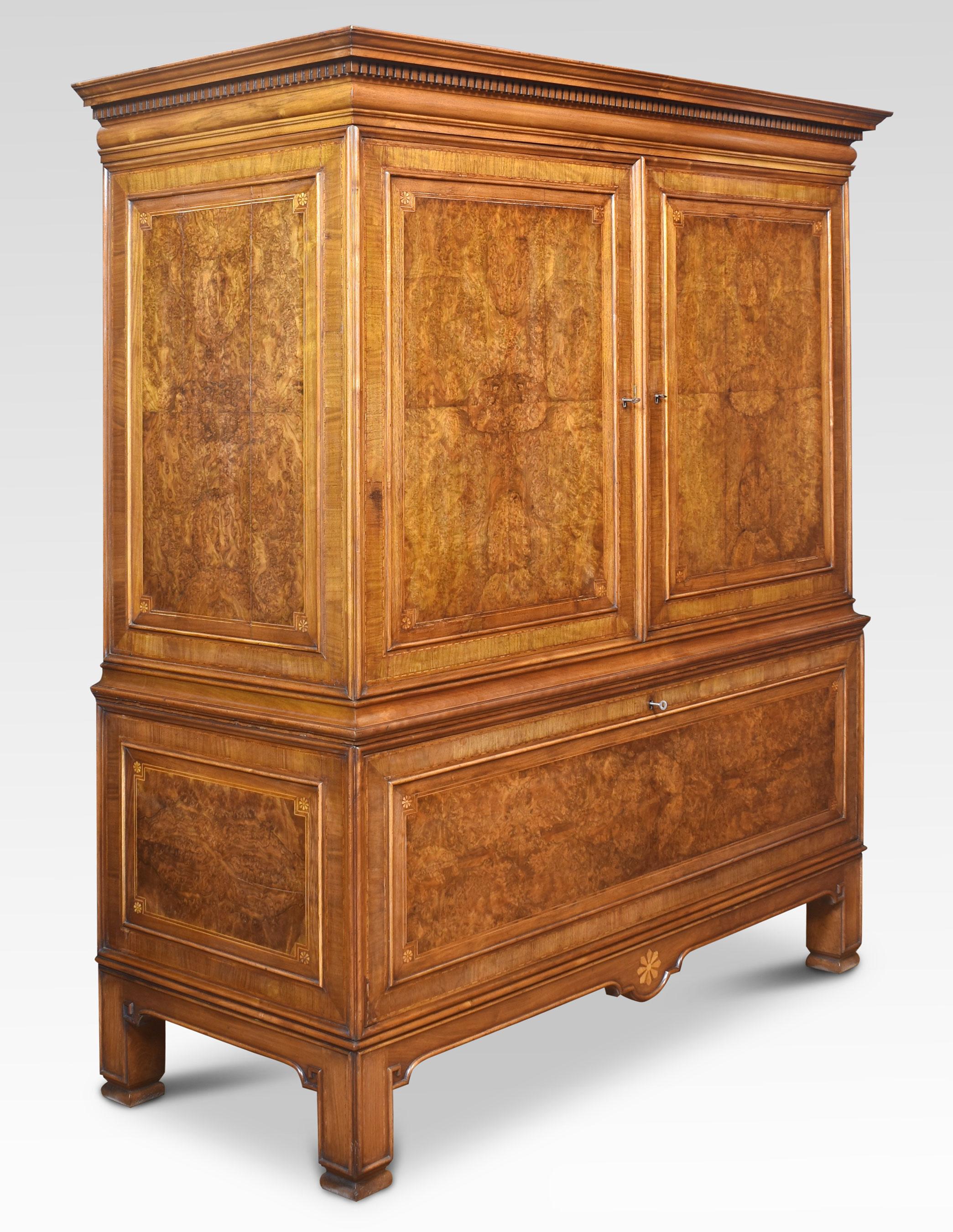 Press cupboard of nice proportions. Having moulded cornice above the large well-figured walnut panelled doors opening to reveal a large cupboard surrounded by four drawers. The base section with unusual well-figured walnut drop-down cupboard door