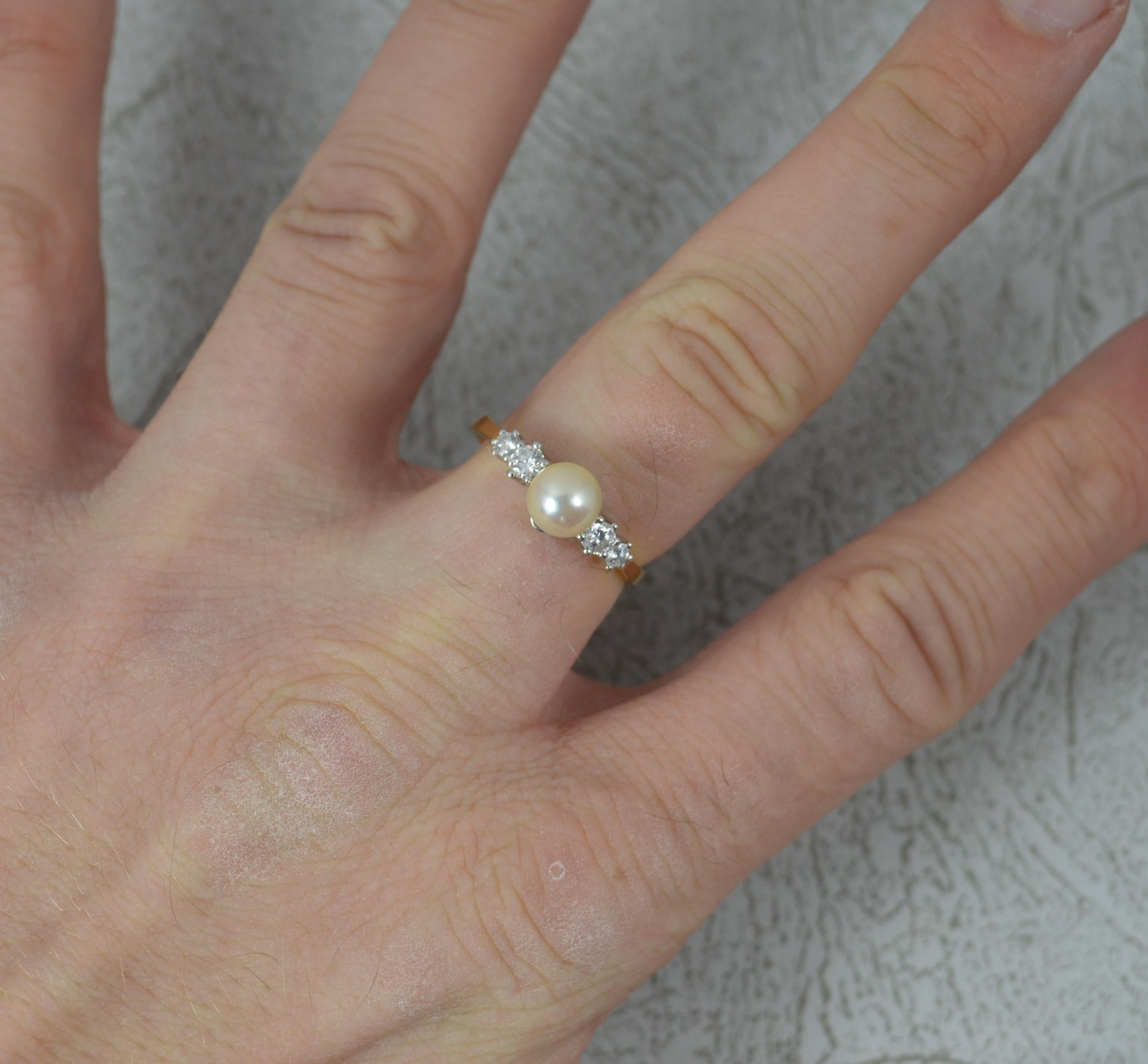 A superb Pearl and Diamond ring.
Solid 18 carat yellow gold shank and platinum claw setting.
Set with a pearl to the centre and two round brilliant cut diamonds to each side.
15mm spread of stones. Protruding 7mm off the finger.

CONDITION ; Very