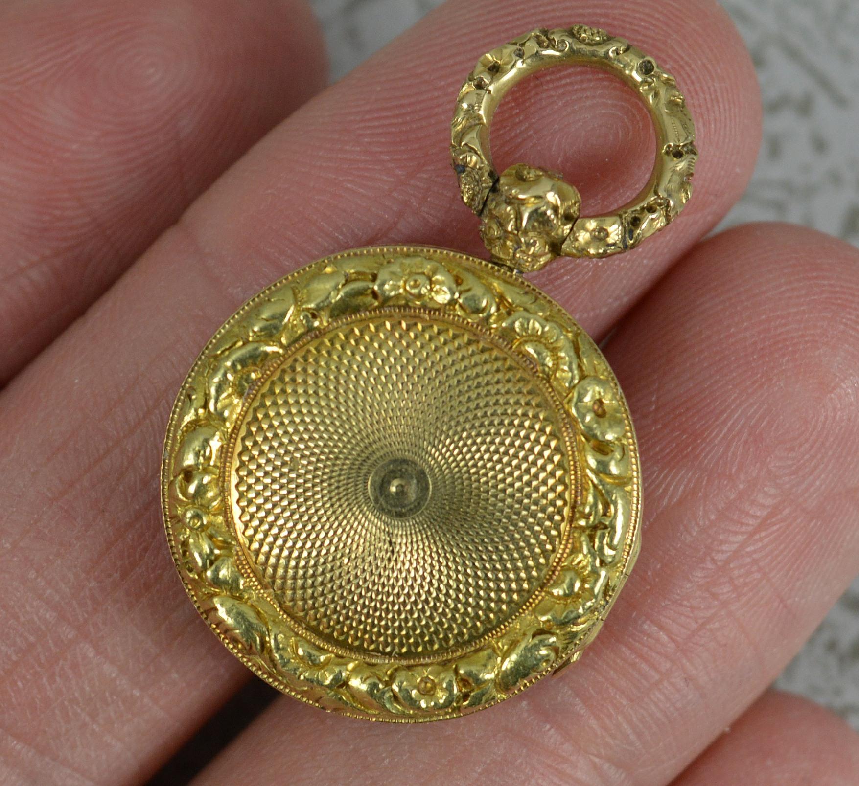 A superb Georgian period locket pendant.
Solid 14 carat yellow gold example.
Fine, deep floral relief border to each side with an engine turned pattern to centre.
Circa 1820.

CONDITION ; Very good for age. Crisp design and hinge. Working clasp.