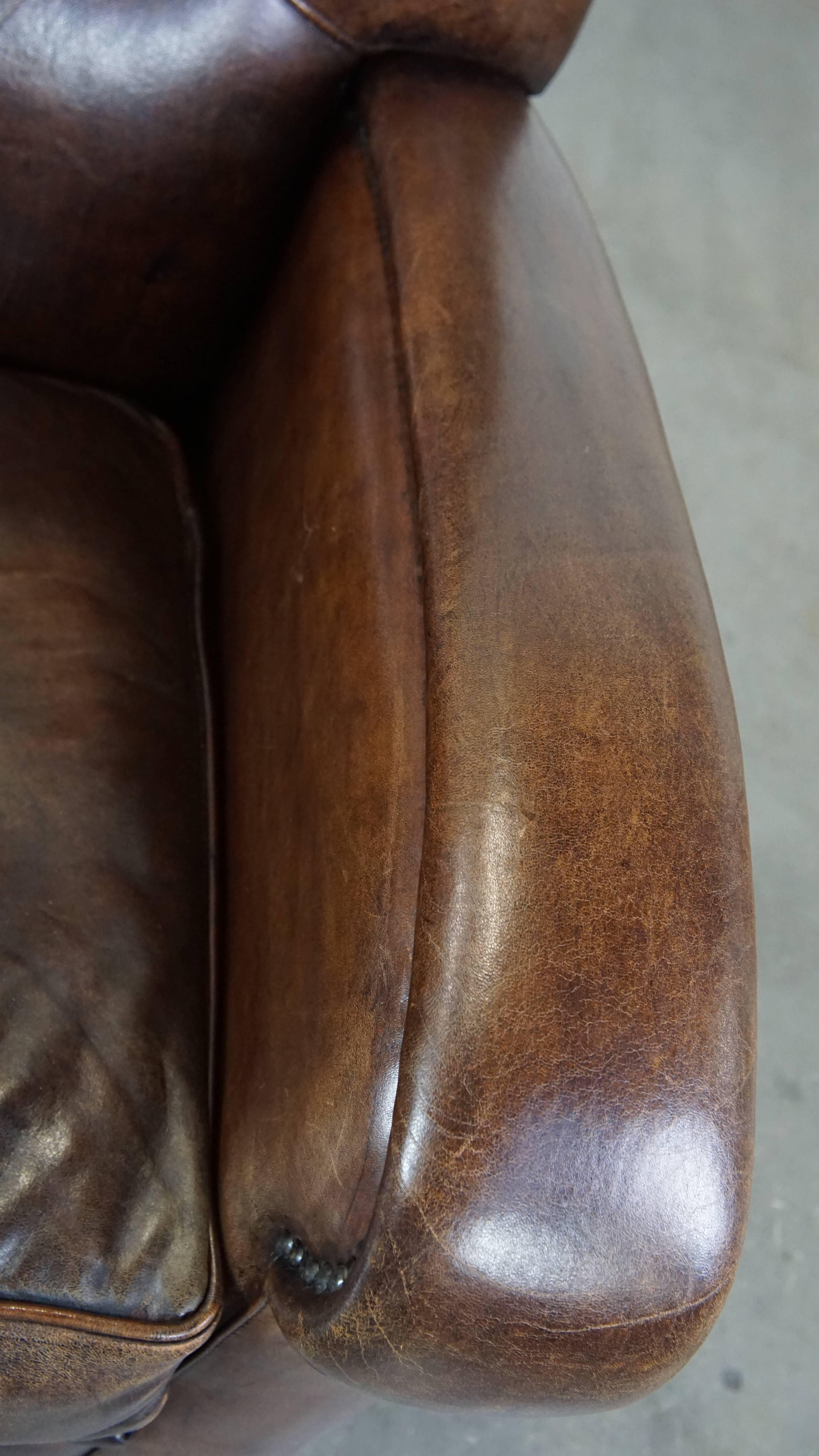 Poltrona in pelle di pecora scura ben curata e confortevole con forme arrotondate in vendita 2