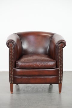 Well-maintained cow leather club armchair in a luxurious red/brown colour