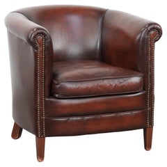 Well-maintained cow leather club armchair in a luxurious red/brown colour