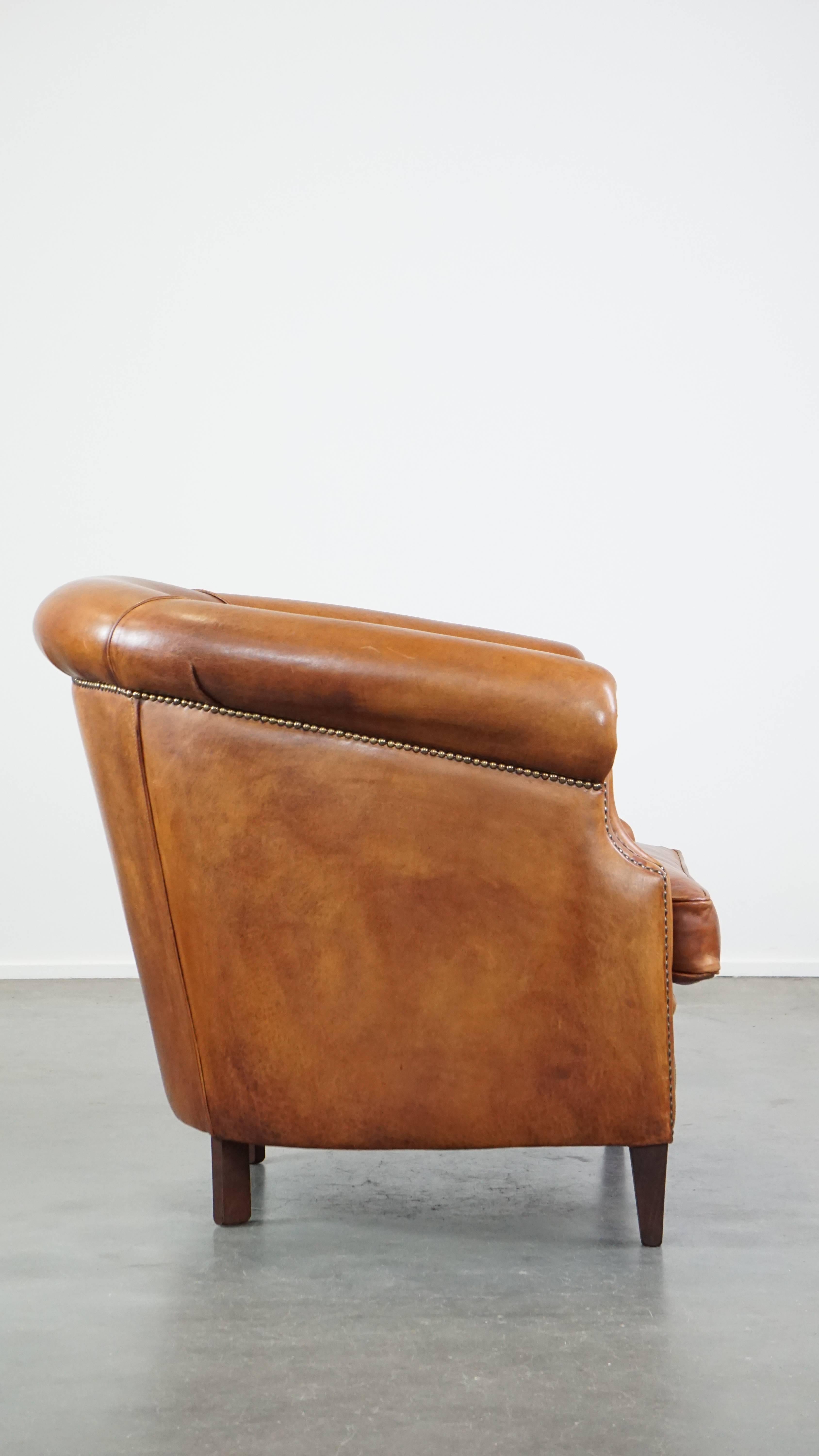 Hand-Crafted Well-maintained sheepskin club armchair with finished with decorative nails For Sale
