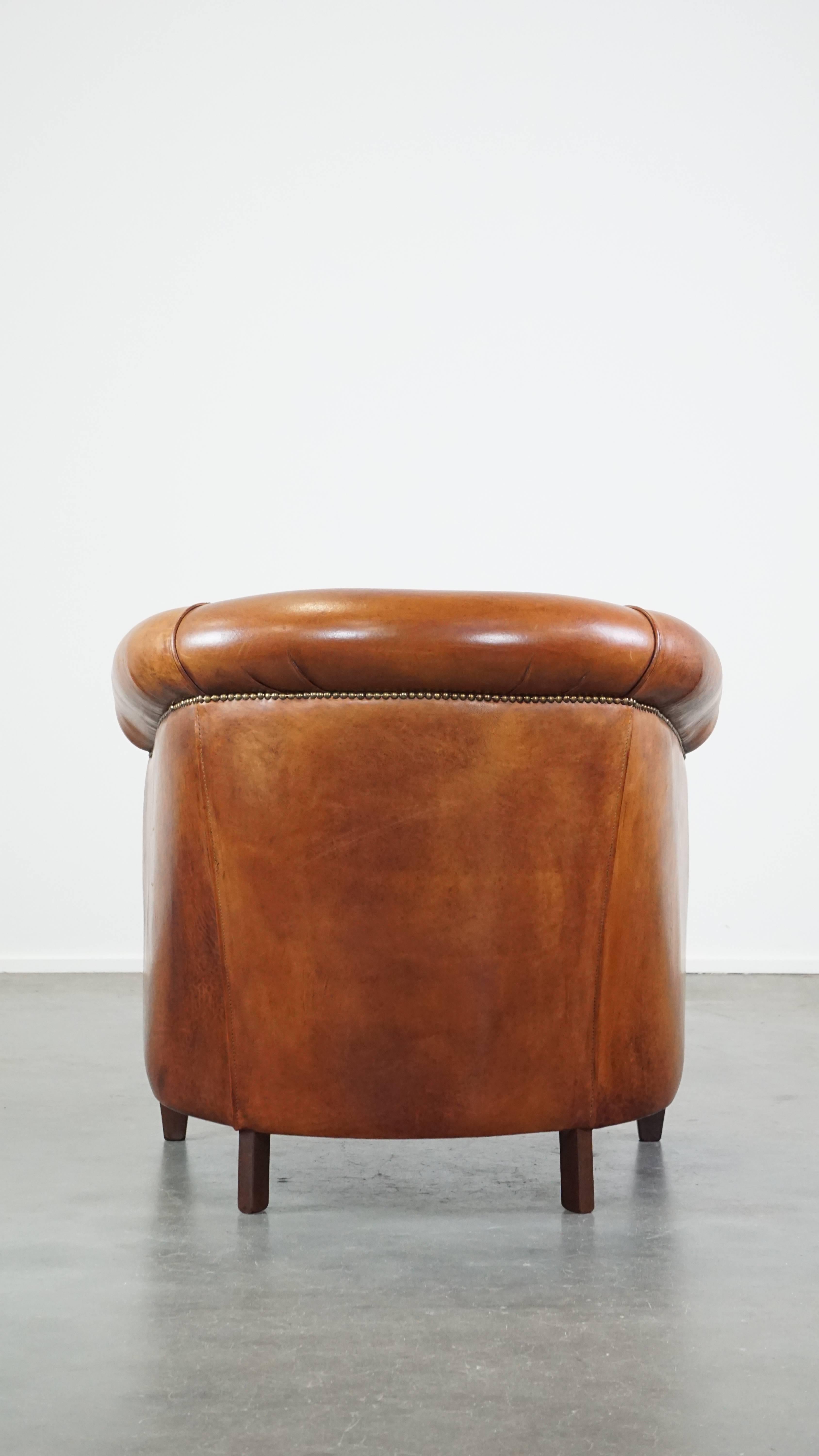 Well-maintained sheepskin club armchair with finished with decorative nails In Good Condition For Sale In Harderwijk, NL