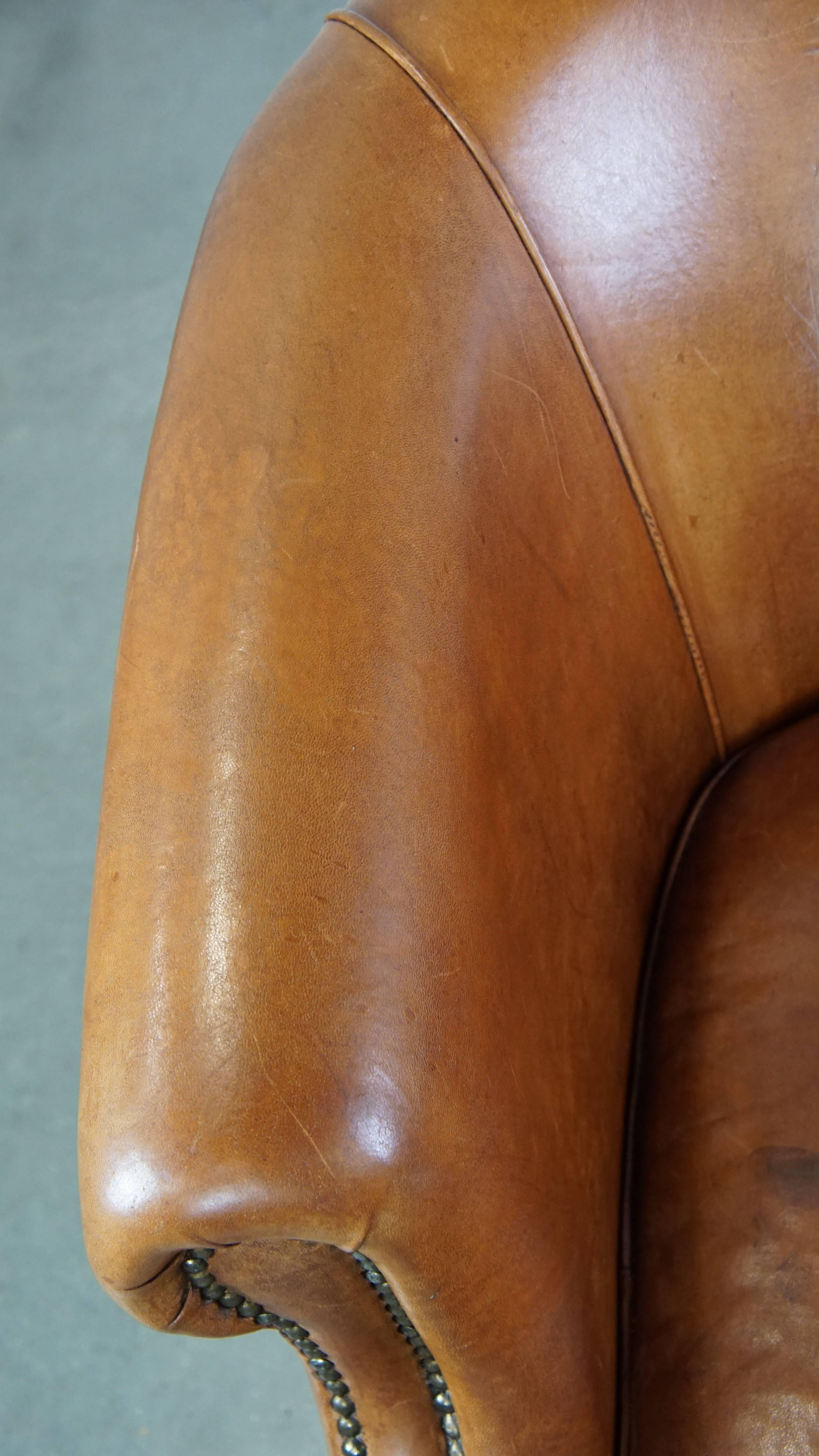 Well-maintained sheepskin club armchair with finished with decorative nails For Sale 1