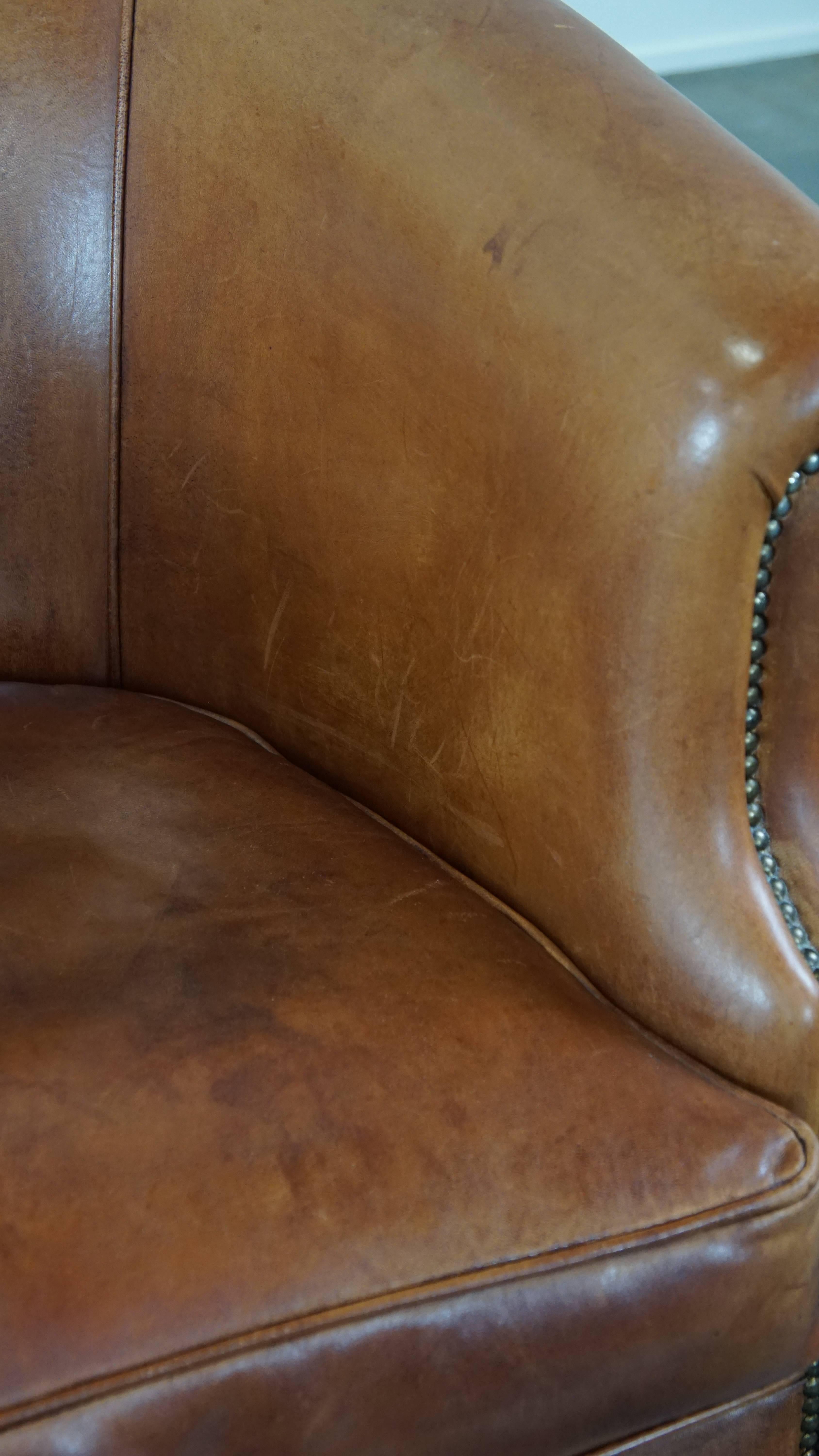 Well-maintained sheepskin club armchair with finished with decorative nails For Sale 3