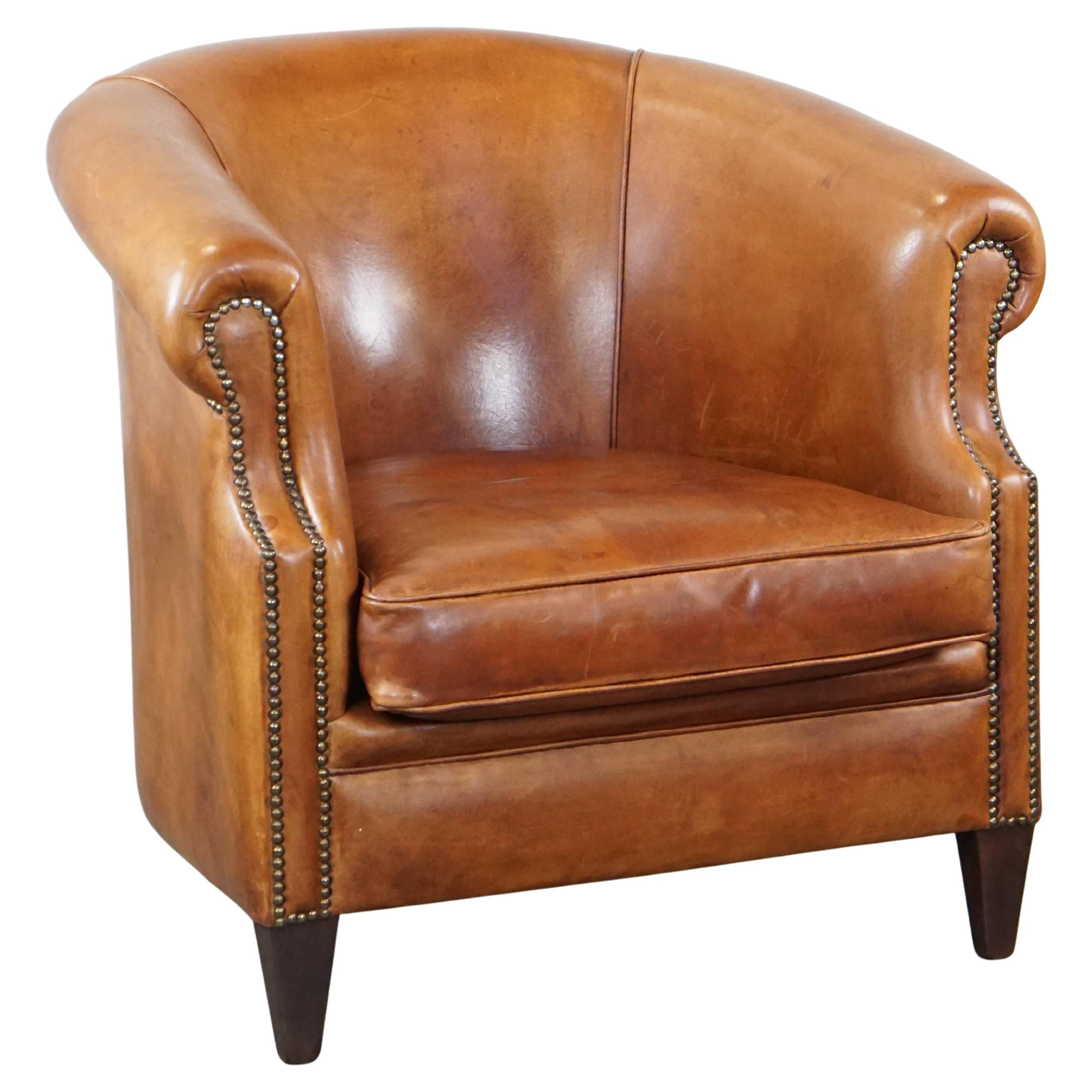 Well-maintained sheepskin club armchair with finished with decorative nails