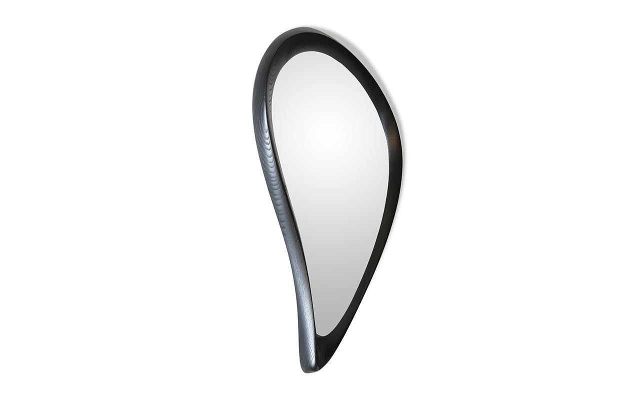 The Wella wall mounted mirror in Ebony stain by Amorph is a luxurious and modern addition to any home. Crafted with high-quality materials and available in different finishes and custom sizes, this mirror is designed to elevate the aesthetic of your