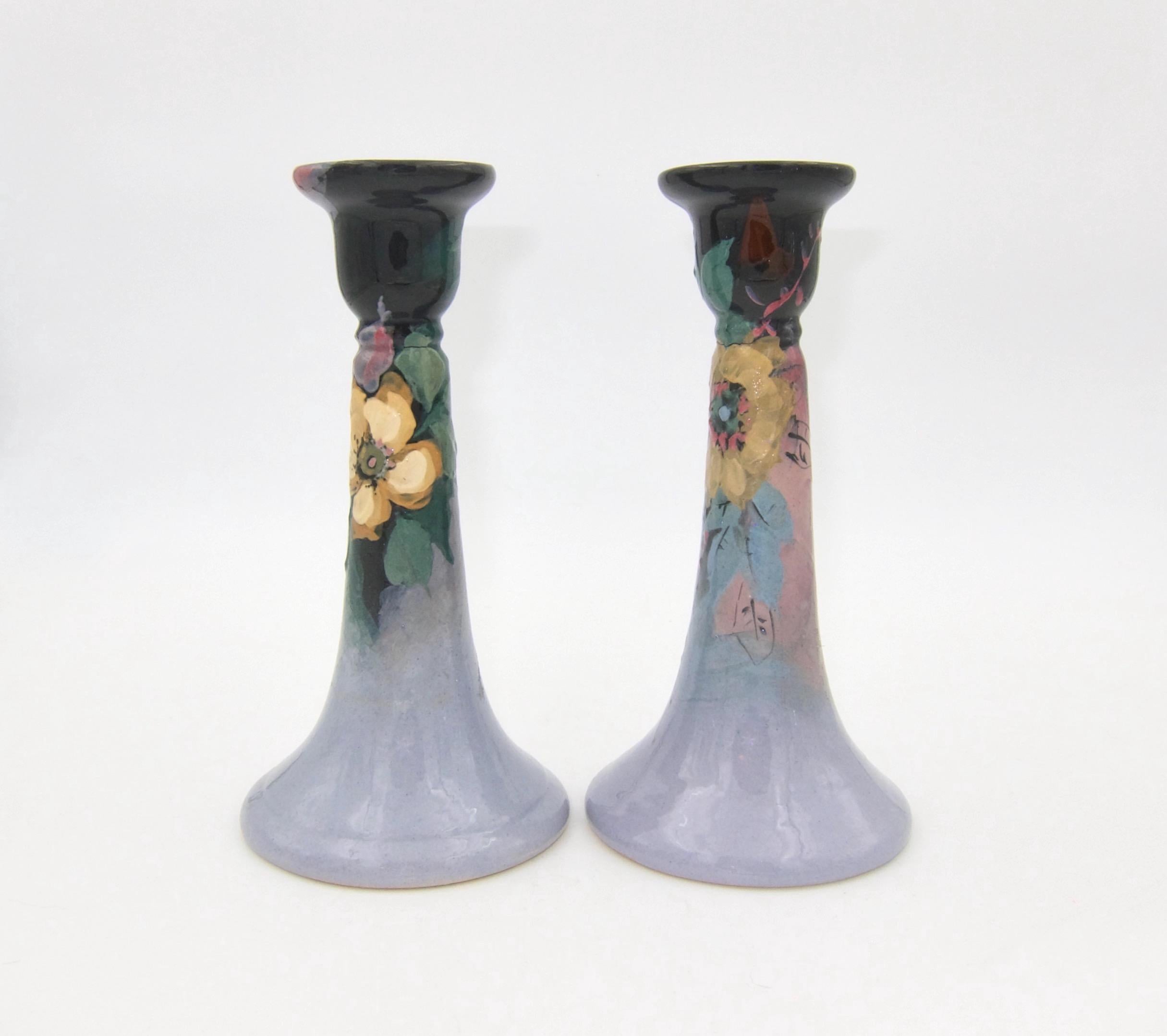 A pair of American Arts & Crafts candle holders from Weller Pottery of Zanesville, Ohio. The antique candlesticks are from Weller's Eocean late line of hand-decorated art pottery. Weller introduced the Eocean decor in 1898, producing it for 20 years