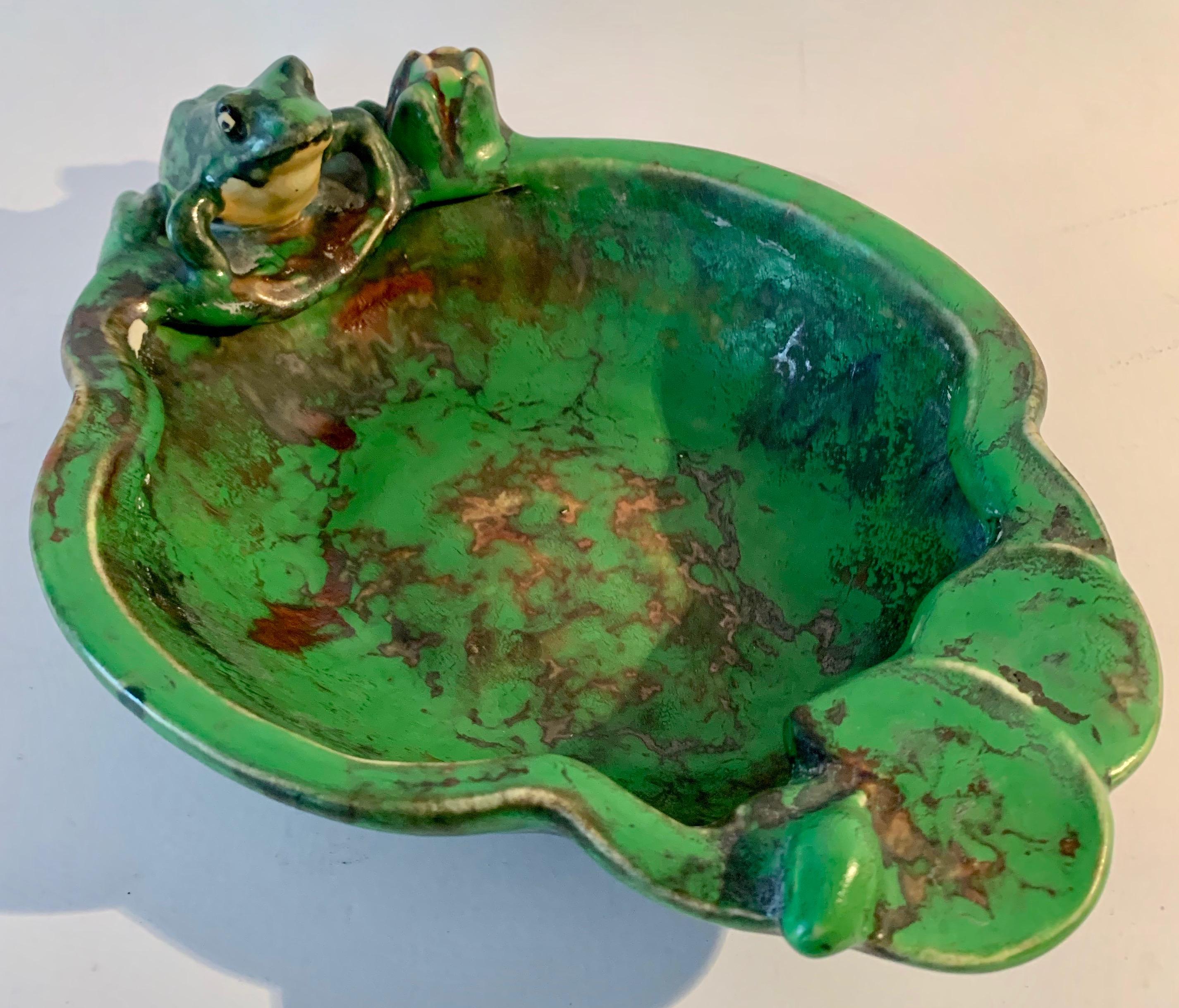 A wonderful bowl of Weller with a rookwood frog and flower. A dish with a frog sitting on a lily pad and in contemplation of getting a hamburger. The piece is numbered 